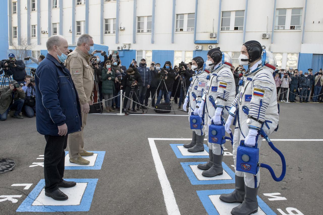 Expedition 65 NASA astronaut Mark Vande Hei, left, Russian cosmonauts Oleg Novitskiy, center, and Pyotr Dubrov report to Roscosmos mission management prior to their Soyuz launch to the International Space Station Friday, April 9, 2021 in Baikonur, Kazakhstan. Photo Credit: (NASA/GCTC/Irina Spector)