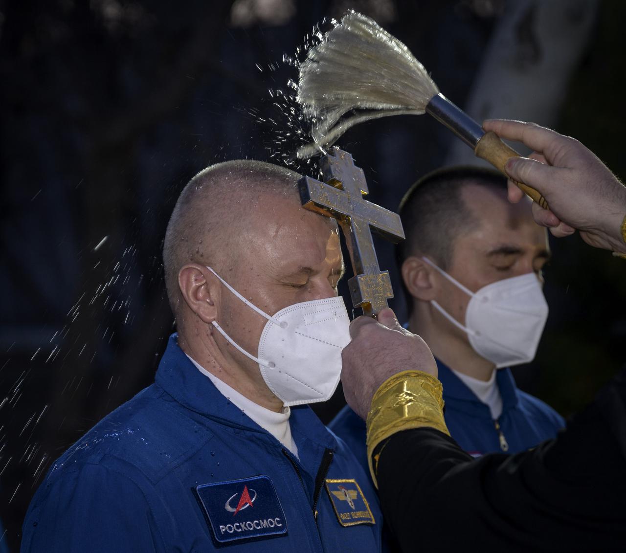 Expedition 65 Russian cosmonaut Oleg Novitskiy receives the traditional blessing outside the Cosmonaut Hotel prior to departing the hotel for launch on a Soyuz rocket with fellow crewmates Russian cosmonaut Pyotr Dubrov and NASA astronaut Mark Vande Hei, Friday, April 9, 2021, in Baikonur, Kazakhstan. Launch of the Soyuz rocket sent the trio on a mission to the International Space Station. Photo Credit: (NASA/Bill Ingalls)