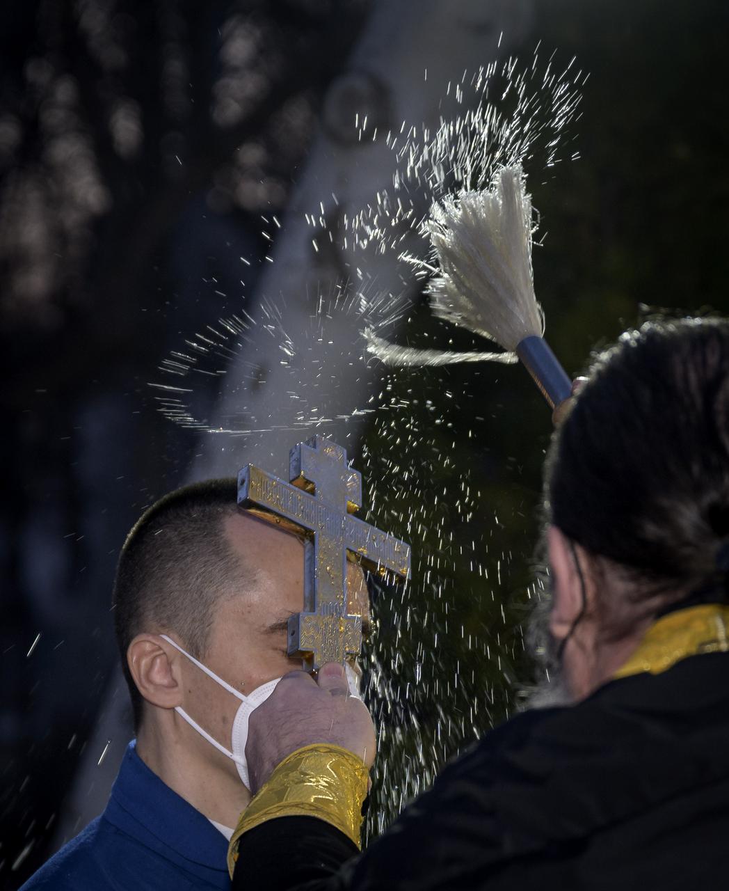 Expedition 65 Russian cosmonaut Pyotr Dubrov receives the traditional blessing outside the Cosmonaut Hotel prior to departing the hotel for launch on a Soyuz rocket with fellow crewmates Russian cosmonaut Oleg Novitskiy and NASA astronaut Mark Vande Hei, Friday, April 9, 2021, in Baikonur, Kazakhstan. Launch of the Soyuz rocket sent the trio on a mission to the International Space Station. Photo Credit: (NASA/Bill Ingalls)