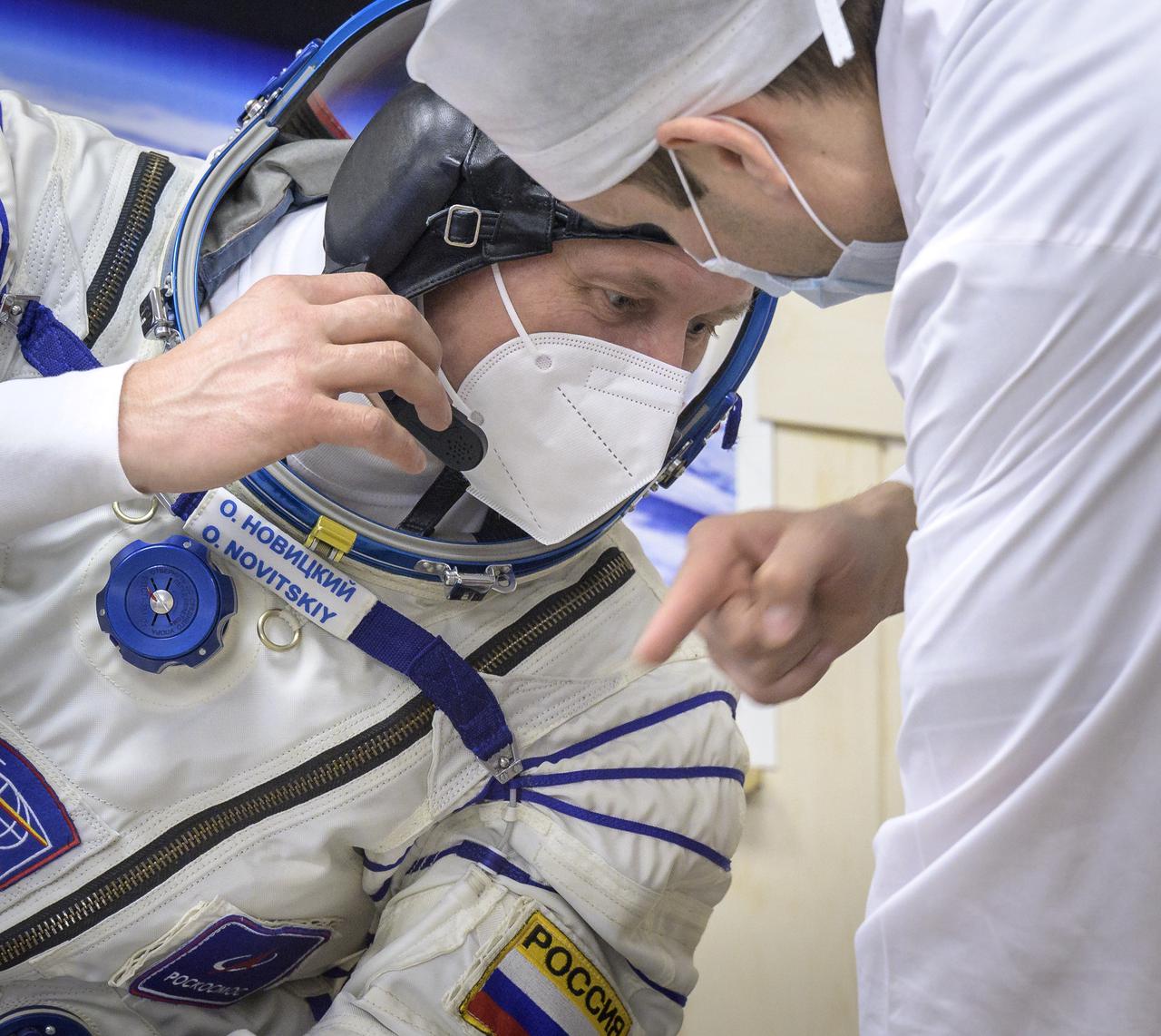 Expedition 65 Russian cosmonaut Oleg Novitskiy talks with a technician after donning his Russian Sokol suit as he and fellow crewmates Russian cosmonaut Pyotr Dubrov and NASA astronaut Mark Vande Hei, prepare for their Soyuz launch to the International Space Station Friday, April 9, 2021 in Baikonur, Kazakhstan. Launch of the Soyuz rocket sent the trio on a mission to the International Space Station. Photo Credit: (NASA/Bill Ingalls)