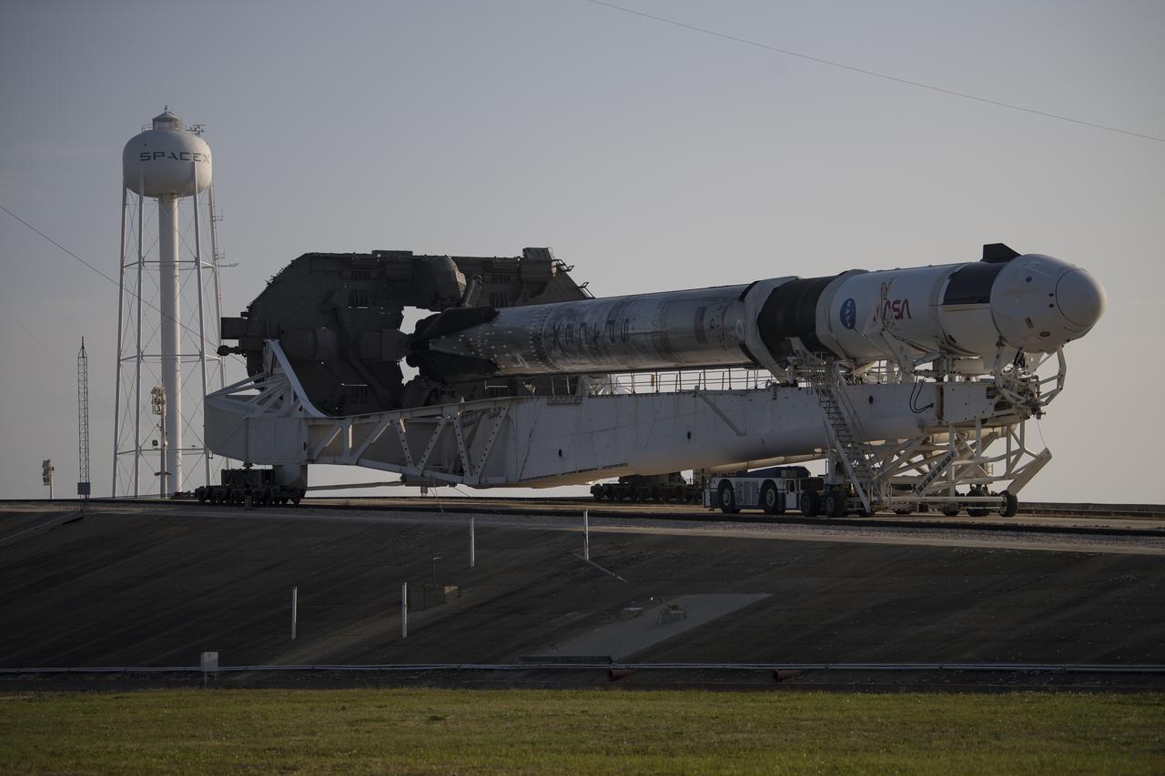 A SpaceX Falcon 9 rocket with the company's Crew Dragon spacecraft onboard is seen as it is rolled to Launch Complex 39A as preparations continue for the Crew-2 mission, Friday, April 16, 2021, at NASA’s Kennedy Space Center in Florida. NASA’s SpaceX Crew-2 mission is the second crew rotation mission of the SpaceX Crew Dragon spacecraft and Falcon 9 rocket to the International Space Station as part of the agency’s Commercial Crew Program. NASA astronauts Shane Kimbrough and Megan McArthur, ESA (European Space Agency) astronaut Thomas Pesquet, and Japan Aerospace Exploration Agency (JAXA) astronaut Akihiko Hoshide are scheduled to launch at 6:11 a.m. ET on Thursday, April 22, from Launch Complex 39A at the Kennedy Space Center. Photo Credit: (NASA/Aubrey Gemignani)