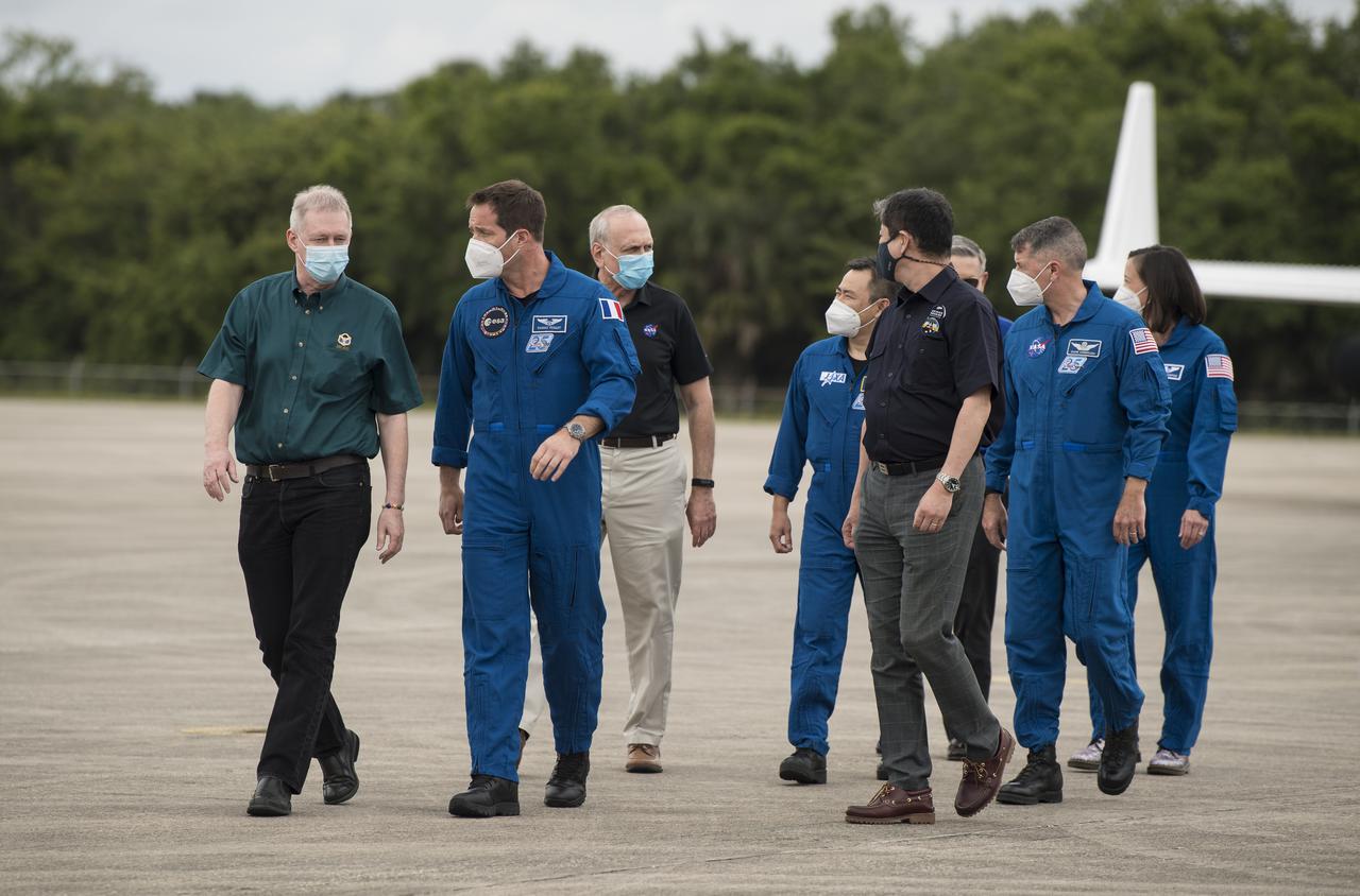From front to back, Frank De Winne, manager, International Space Station Program, ESA (European Space Agency) walks with ESA astronaut Thomas Pesquet; Steve Jurczyk, acting NASA Administrator, walks with Junichi Sakai, manager, International Space Station Program, Japan Aerospace Exploration Agency (JAXA), and JAXA astronaut Akihiko Hoshide; and Bob Cabana, director, Kennedy Space Center, walks with NASA astronauts Megan McArthur and Shane Kimbrough, after the astronauts arrived at the Launch and Landing Facility at NASA’s Kennedy Space Center ahead of SpaceX’s Crew-2 mission, Friday, April 16, 2021, in Florida. NASA’s SpaceX Crew-2 mission is the second operational mission of the SpaceX Crew Dragon spacecraft and Falcon 9 rocket to the International Space Station as part of the agency’s Commercial Crew Program. Kimbrough, McArthur, Pesquet, and Hoshide are scheduled to launch at 6:11 a.m. ET on Thursday, April 22, from Launch Complex 39A at the Kennedy Space Center. Photo Credit: (NASA/Aubrey Gemignani)