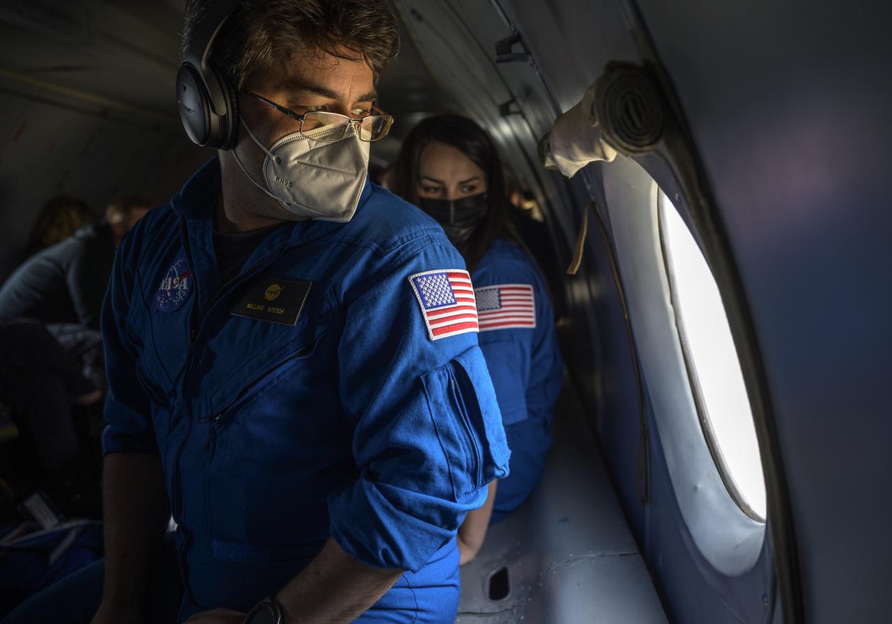 Manager, NASA ISS Transportation Integration Office, Bill Spetch, left, and NASA Public Affairs Officer Courtney Beasley look out the window of an AN-26 aircraft as they fly form Karaganda to Zhezkazgan, Kazakhstan to prepare for the Soyuz MS-17 landing of Expedition 64 crew members Kate Rubins of NASA, Sergey Ryzhikov and Sergey Kud-Sverchkov of Roscosmos, Friday, April 16, 2021. Rubins, Ryzhikov and Kud-Sverchkov will be returning April 17 after 185 days in space having served as Expedition 63-64 crew members onboard the International Space Station. Photo Credit: NASA/Bill Ingalls
