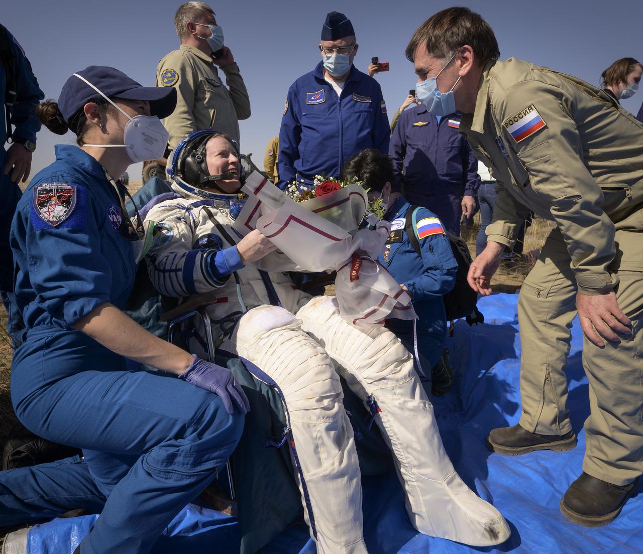 Expedition 64 NASA astronaut Kate Rubins smiles as Adviser to the Head of Gagarin Cosmonaut Training Center (GCTC) Yuri Malenchenko gives her flowers and welcomes her home after she, and Roscosmos cosmonauts Sergey Ryzhikov and Sergey Kud-Sverchkov landed there Soyuz MS-17 spacecraft in a remote area near the town of Zhezkazgan, Kazakhstan on Saturday, April 17, 2021. Rubins, Ryzhikov and Kud-Sverchkov returned after 185 days in space having served as Expedition 63-64 crew members onboard the International Space Station. Photo Credit: NASA/Bill Ingalls