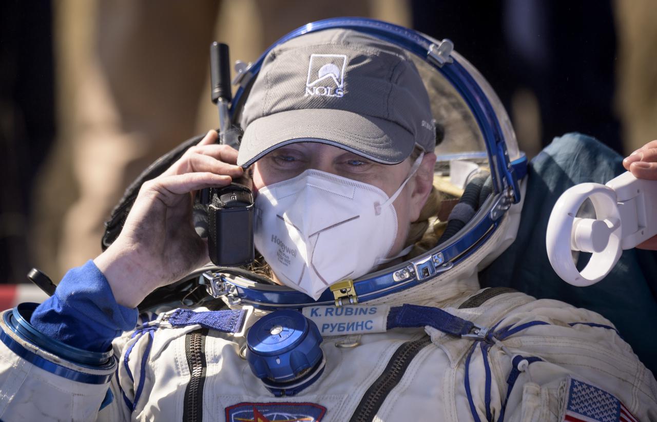 Expedition 64 NASA astronaut Kate Rubins talks to family via satellite phone outside the Soyuz MS-17 spacecraft after she, Roscosmos cosmonauts Sergey Ryzhikov and Sergey Kud-Sverchkov landed in a remote area near the town of Zhezkazgan, Kazakhstan on Saturday, April 17, 2021. Rubins, Ryzhikov and Kud-Sverchkov returned after 185 days in space having served as Expedition 63-64 crew members onboard the International Space Station. Photo Credit: NASA/Bill Ingalls