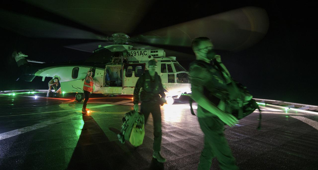 NASA and SpaceX support teams arrive via helicopter to the SpaceX GO Navigator recovery ship in order to prepare for the landing of the SpaceX Crew Dragon Resilience spacecraft with NASA astronauts Mike Hopkins, Shannon Walker, and Victor Glover, and Japan Aerospace Exploration Agency (JAXA) astronaut Soichi Noguchi aboard in the Gulf of Mexico off the coast of Panama City, Florida, Saturday, May 1, 2021. NASA’s SpaceX Crew-1 mission is the first crew rotation flight of the SpaceX Crew Dragon spacecraft and Falcon 9 rocket with astronauts to the International Space Station as part of the agency’s Commercial Crew Program. Photo Credit: (NASA/Bill Ingalls)