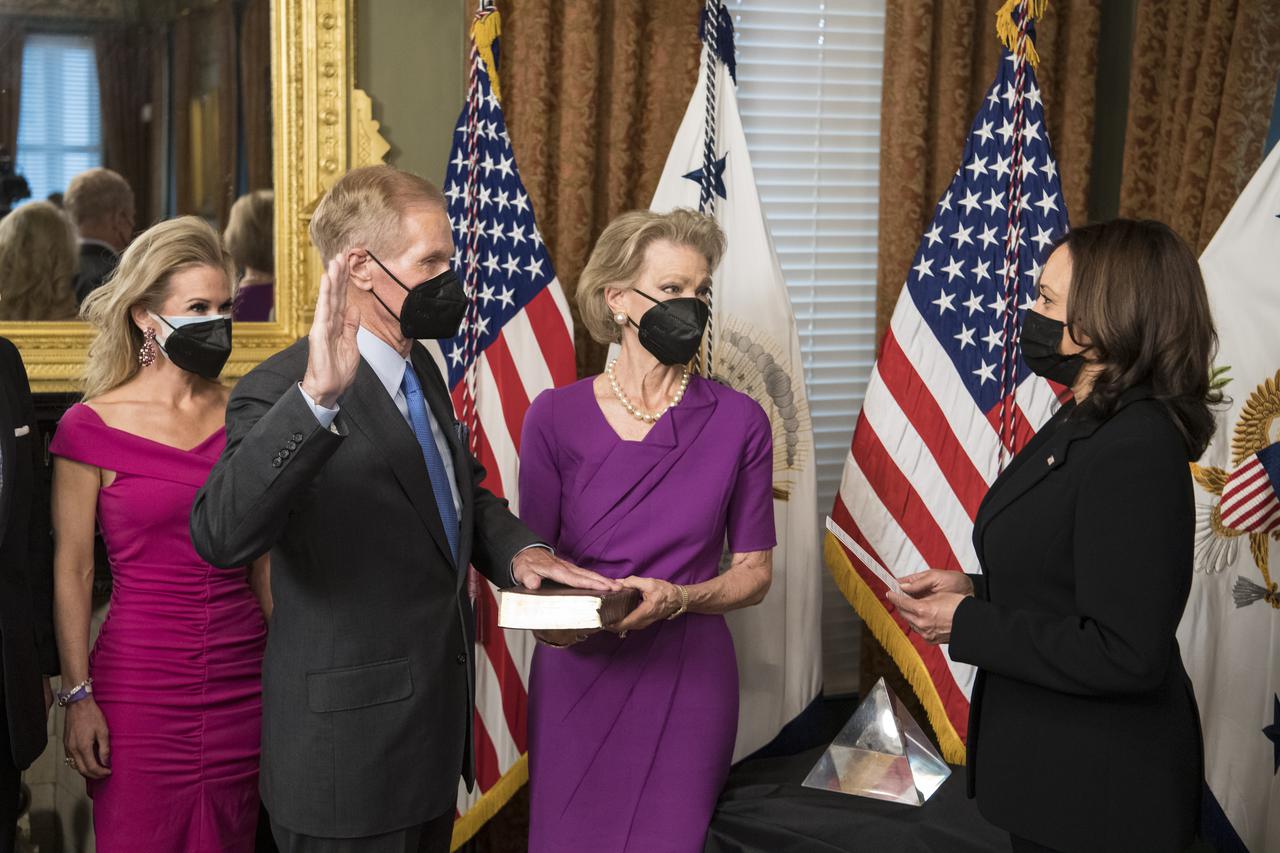 Former Senator Bill Nelson, is ceremonially sworn-in as the 14th NASA Administrator by Vice President Kamala Harris, as his wife, Grace Nelson, holds their family Bible, and his daughter, Nan Ellen Nelson, left, looks on, Monday, May 3, 2021, at the Ceremonial Office in the Old Executive Office Building in Washington. A moon rock collected by astronaut John Young during the Apollo 16 mission was on display and former NASA Administrators Jim Bridenstine (virtually on laptop) and Charles Bolden were also present. Photo Credit: (NASA/Aubrey Gemignani)