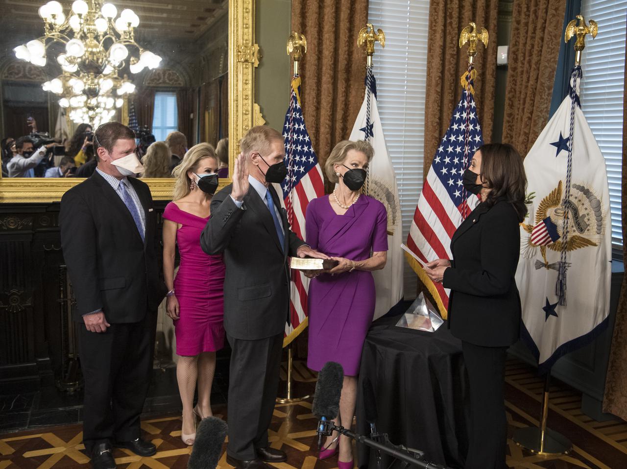 Former Senator Bill Nelson, is ceremonially sworn-in as the 14th NASA Administrator by Vice President Kamala Harris, as his wife, Grace Nelson, holds their family Bible, and son, Bill Nelson Jr., left, and Nan Ellen Nelson, second from left, look on, Monday, May 3, 2021, at the Ceremonial Office in the Old Executive Office Building in Washington. A moon rock collected by astronaut John Young during the Apollo 16 mission was on display and former NASA Administrators Jim Bridenstine (virtually on laptop) and Charles Bolden were also present. Photo Credit: (NASA/Aubrey Gemignani)