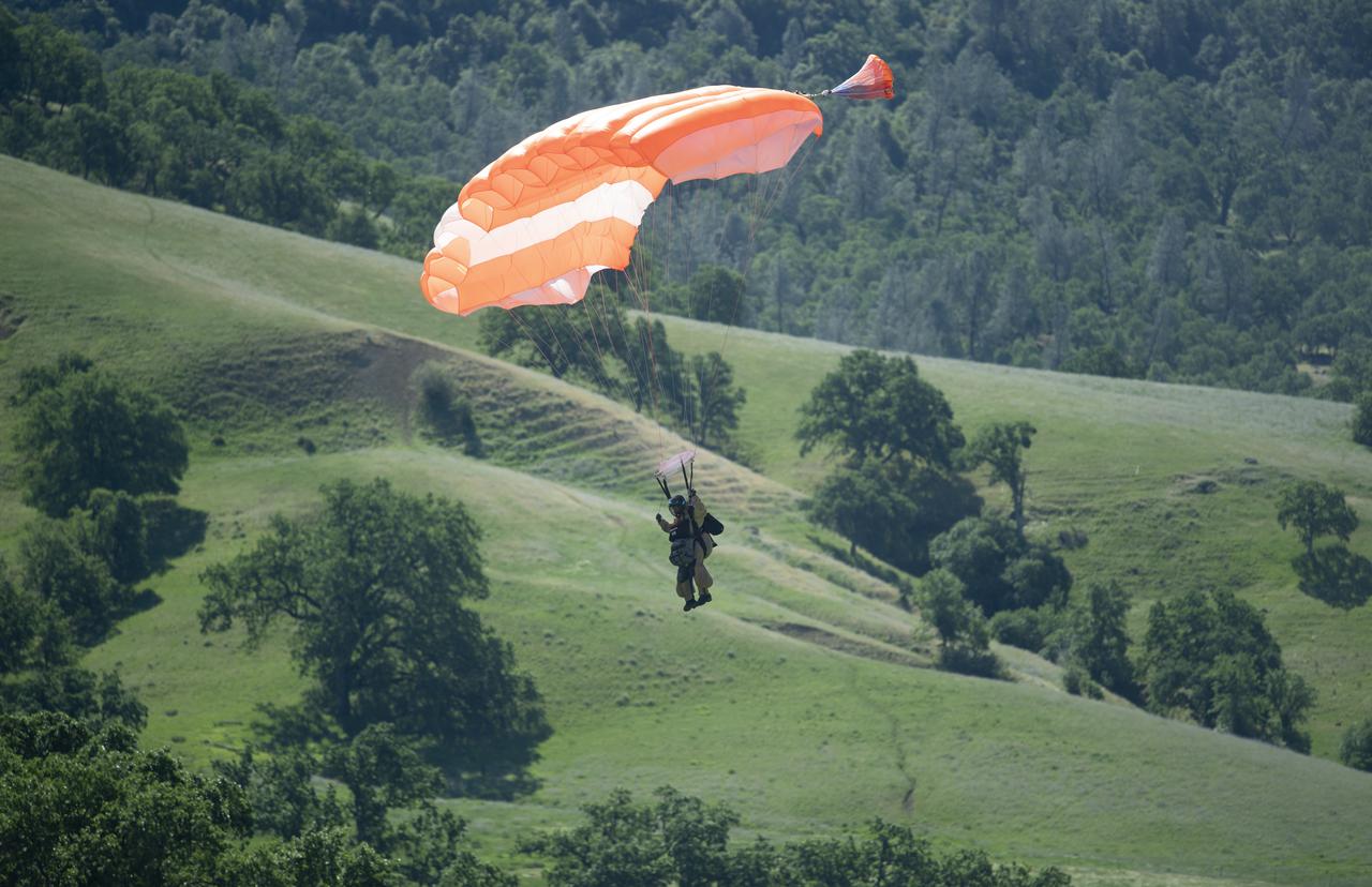 A smokejumper is seen during a training jump onto a simulated wildfire, Tuesday, May 4, 2021 as Cal Fire conducts aerial fire fighting training exercises near Redding, California.  STEReO, the Scalable Traffic Management for Emergency Response Operations project, led by NASA’s Ames Research Center, builds on NASA’s expertise in air traffic management, human factors research, and autonomous technology development to apply the agency’s work in Unmanned Aircraft Systems Traffic Management, or UTM, to public safety uses. Photo Credit: (NASA/Joel Kowsky)