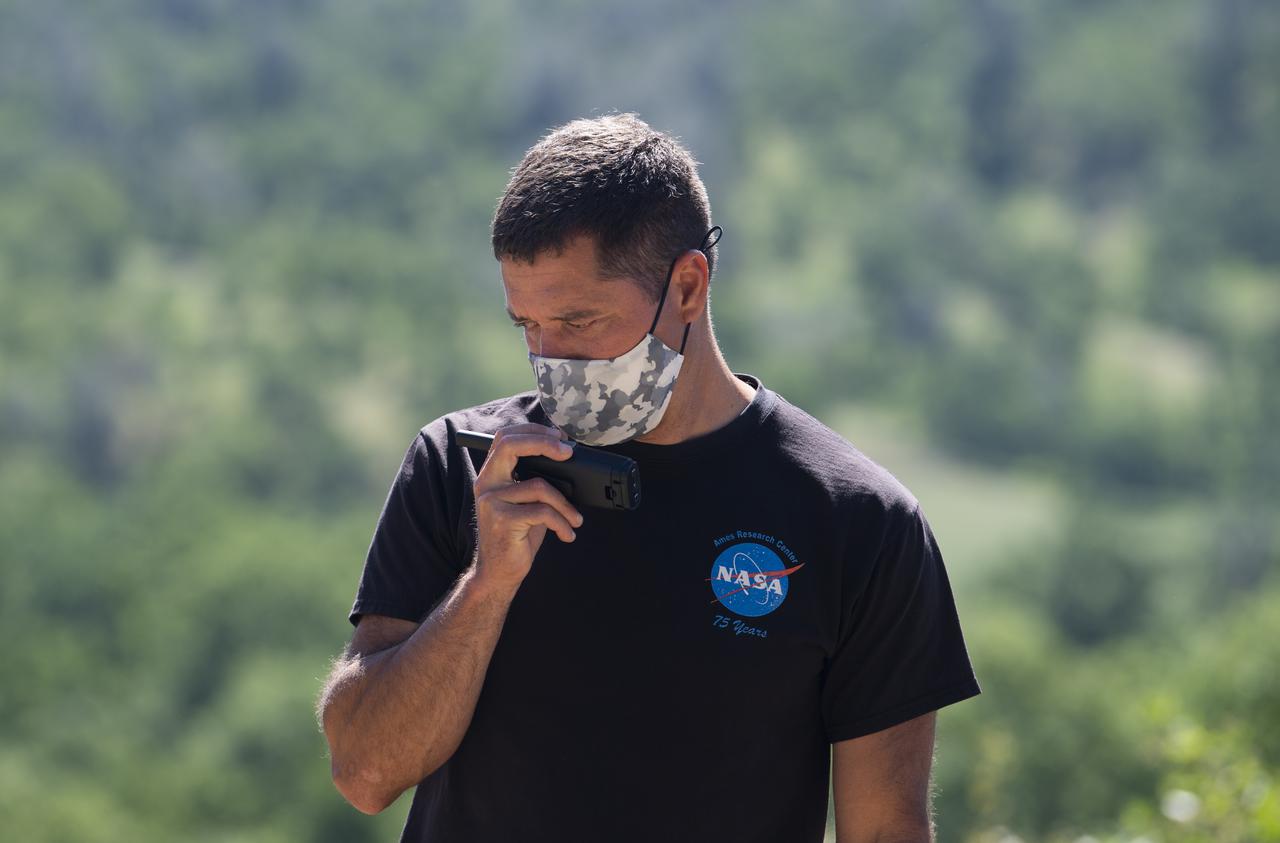 Joey Mercer, principle investigator for STEReO, the Scalable Traffic Management for Emergency Response Operations project,  at NASA's Ames Research Center, is seen making a radio call during STEReO field testing, Tuesday, May 4, 2021 as Cal Fire conducts aerial fire fighting training exercises near Redding, California.  STEReO, the Scalable Traffic Management for Emergency Response Operations project, led by NASA’s Ames Research Center, builds on NASA’s expertise in air traffic management, human factors research, and autonomous technology development to apply the agency’s work in Unmanned Aircraft Systems Traffic Management, or UTM, to public safety uses. Photo Credit: (NASA/Joel Kowsky)