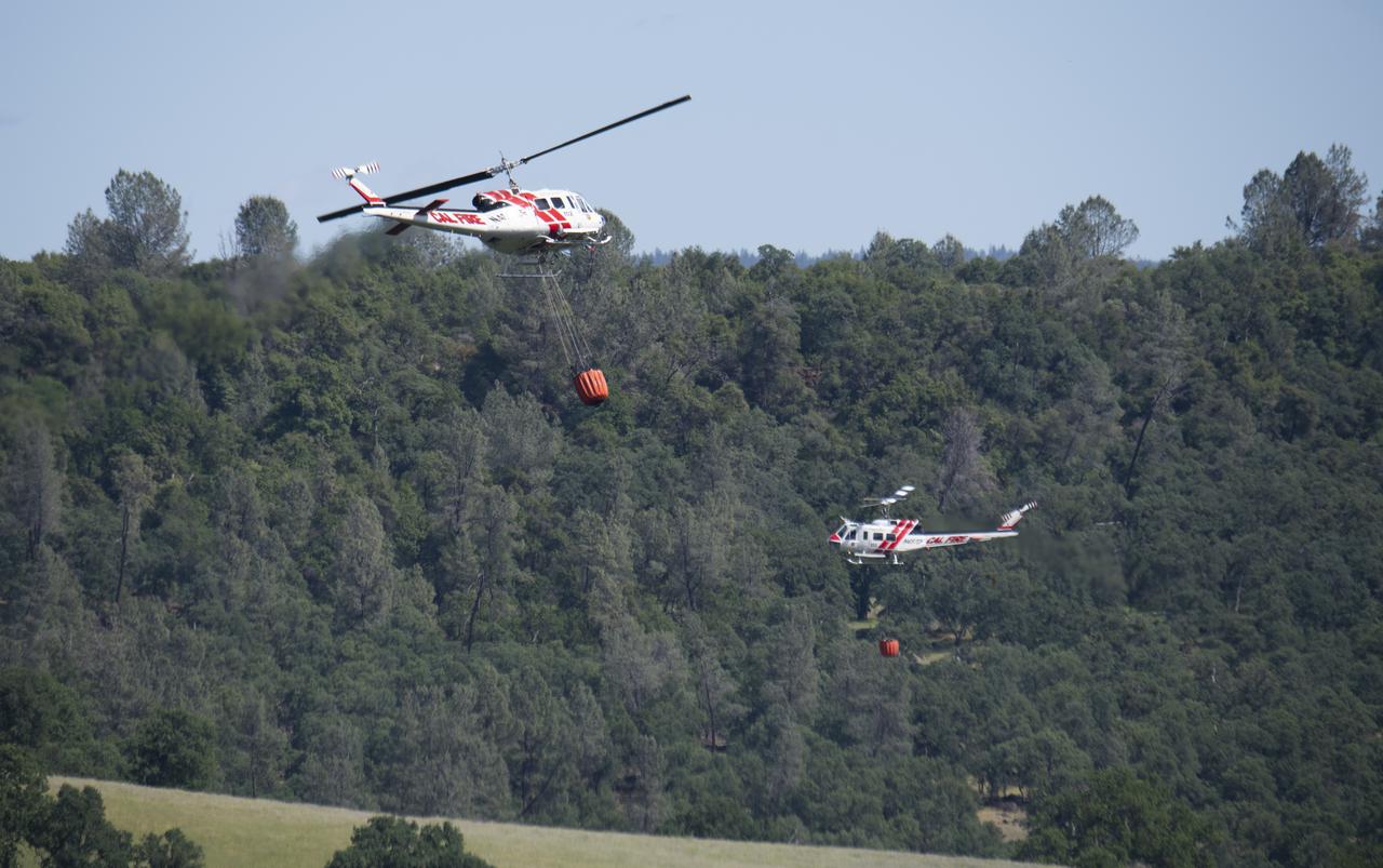 A pair of Cal Fire UH-1H Super Huey helicopters are seen during an aerial attack on a simulated wildfire, Tuesday, May 4, 2021 as Cal Fire conducts aerial fire fighting training exercises near Redding, California. STEReO, the Scalable Traffic Management for Emergency Response Operations project, led by NASA’s Ames Research Center, builds on NASA’s expertise in air traffic management, human factors research, and autonomous technology development to apply the agency’s work in Unmanned Aircraft Systems Traffic Management, or UTM, to public safety uses. Photo Credit: (NASA/Joel Kowsky)