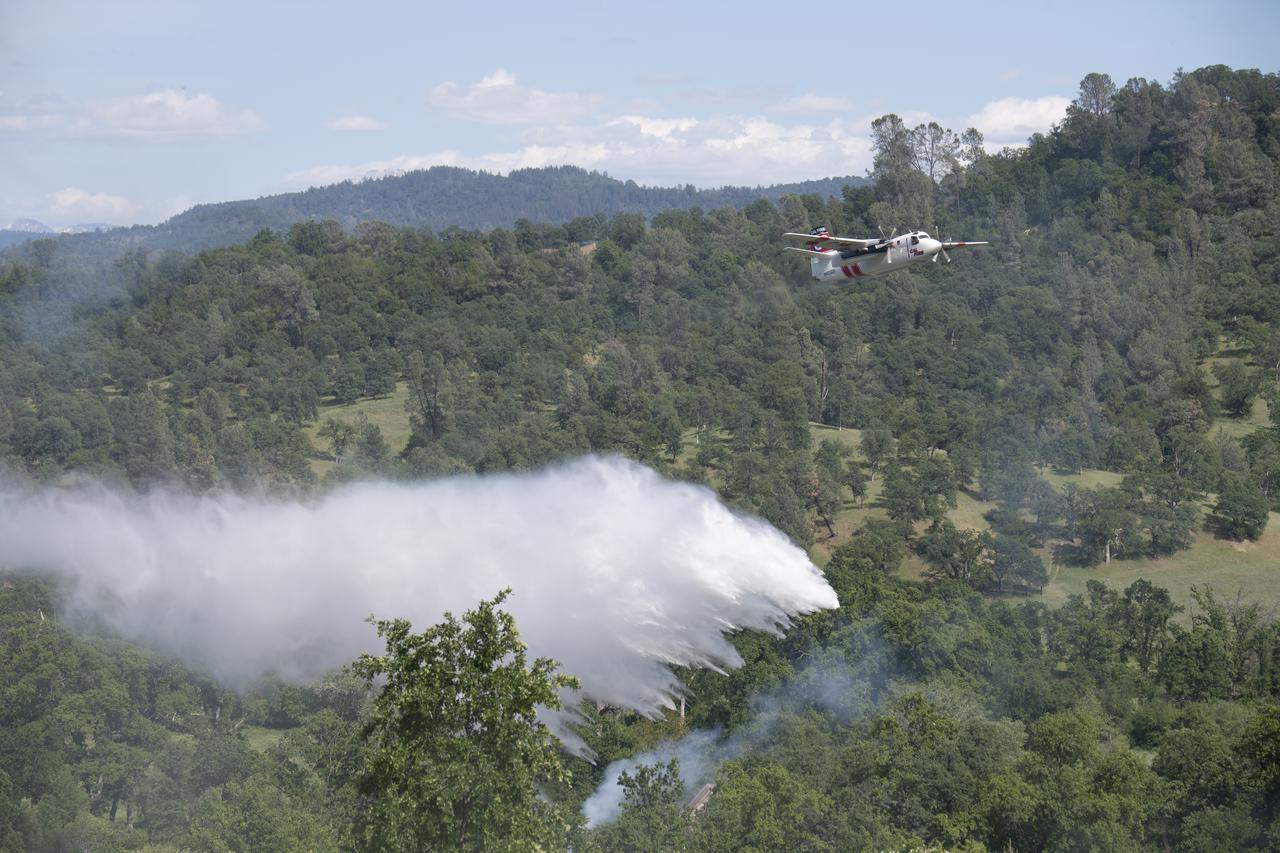 A Cal Fire S2-T airtanker drops water on a simulated wildfire, Tuesday, May 4, 2021, as Cal Fire conducts aerial fire fighting training exercises near Redding, California. STEReO, the Scalable Traffic Management for Emergency Response Operations project, led by NASA’s Ames Research Center, builds on NASA’s expertise in air traffic management, human factors research, and autonomous technology development to apply the agency’s work in Unmanned Aircraft Systems Traffic Management, or UTM, to public safety uses. Photo Credit: (NASA/Joel Kowsky)