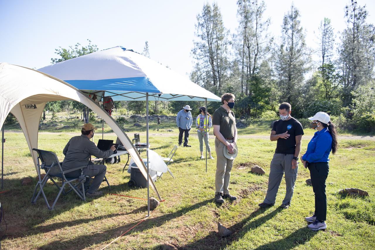 Joey Mercer, principle investigator for STEReO, the Scalable Traffic Management for Emergency Response Operations project, at NASA's Ames Research Center, center, speaks with Richard Barhydt, station director of the U.S. Forest Service's Pacific Southwest Research Station, left, and Huy Tran, director of aeronautics at NASA's Ames Research Center, right, during STEReO test activities, Tuesday, May 4, 2021 as Cal Fire conducts aerial fire fighting training exercises near Redding, California. STEReO, the Scalable Traffic Management for Emergency Response Operations project, led by NASA’s Ames Research Center, builds on NASA’s expertise in air traffic management, human factors research, and autonomous technology development to apply the agency’s work in Unmanned Aircraft Systems Traffic Management, or UTM, to public safety uses. Photo Credit: (NASA/Joel Kowsky)