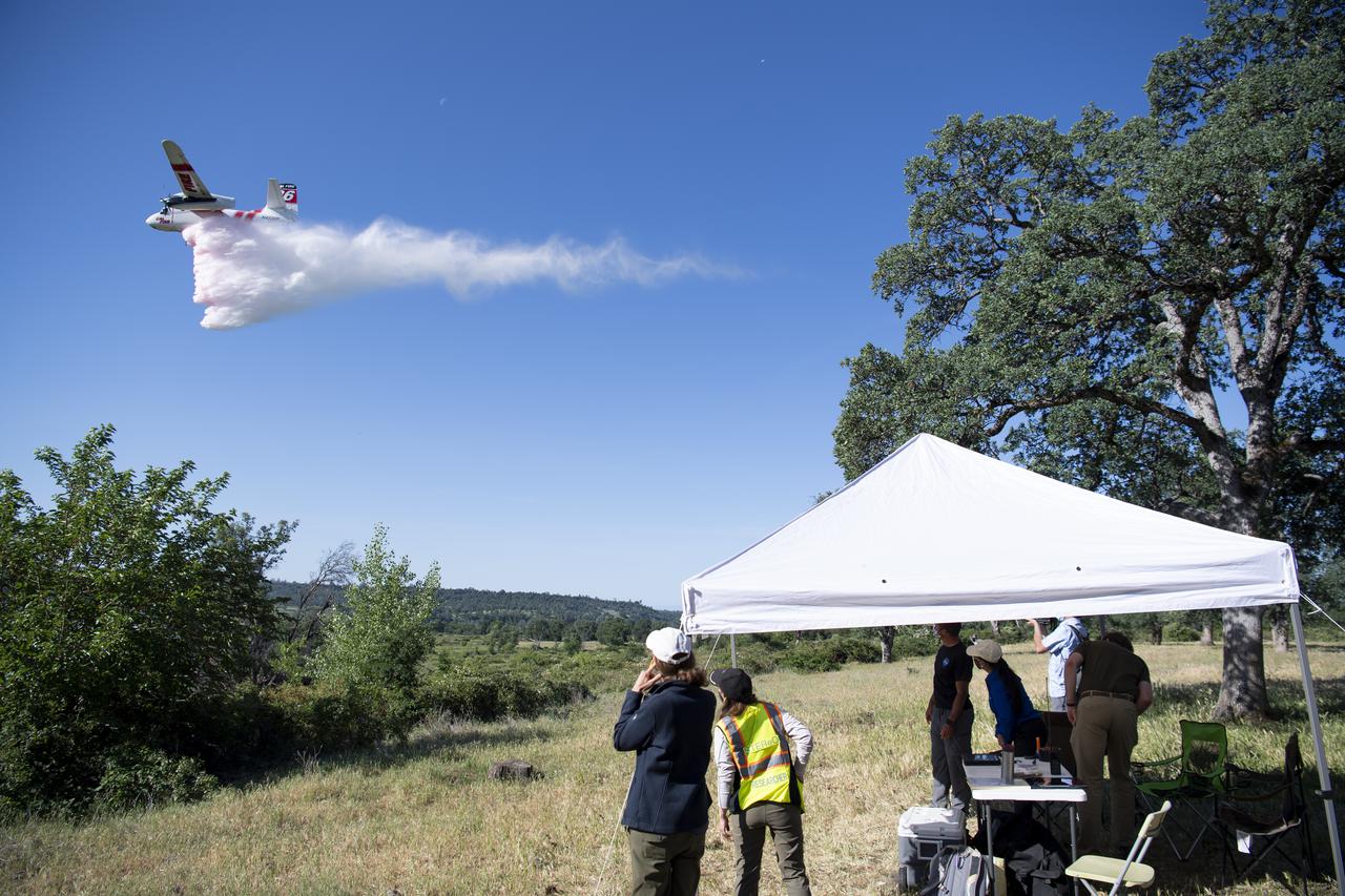 STEReO, the Scalable Traffic Management for Emergency Response Operations project, team members watch as a Cal Fire S2-T airtanker drops water on a simulated wildfire, Tuesday, May 4, 2021 as Cal Fire conducts aerial fire fighting training exercises near Redding, California.  STEReO, the Scalable Traffic Management for Emergency Response Operations project, led by NASA’s Ames Research Center, builds on NASA’s expertise in air traffic management, human factors research, and autonomous technology development to apply the agency’s work in Unmanned Aircraft Systems Traffic Management, or UTM, to public safety uses. Photo Credit: (NASA/Joel Kowsky)