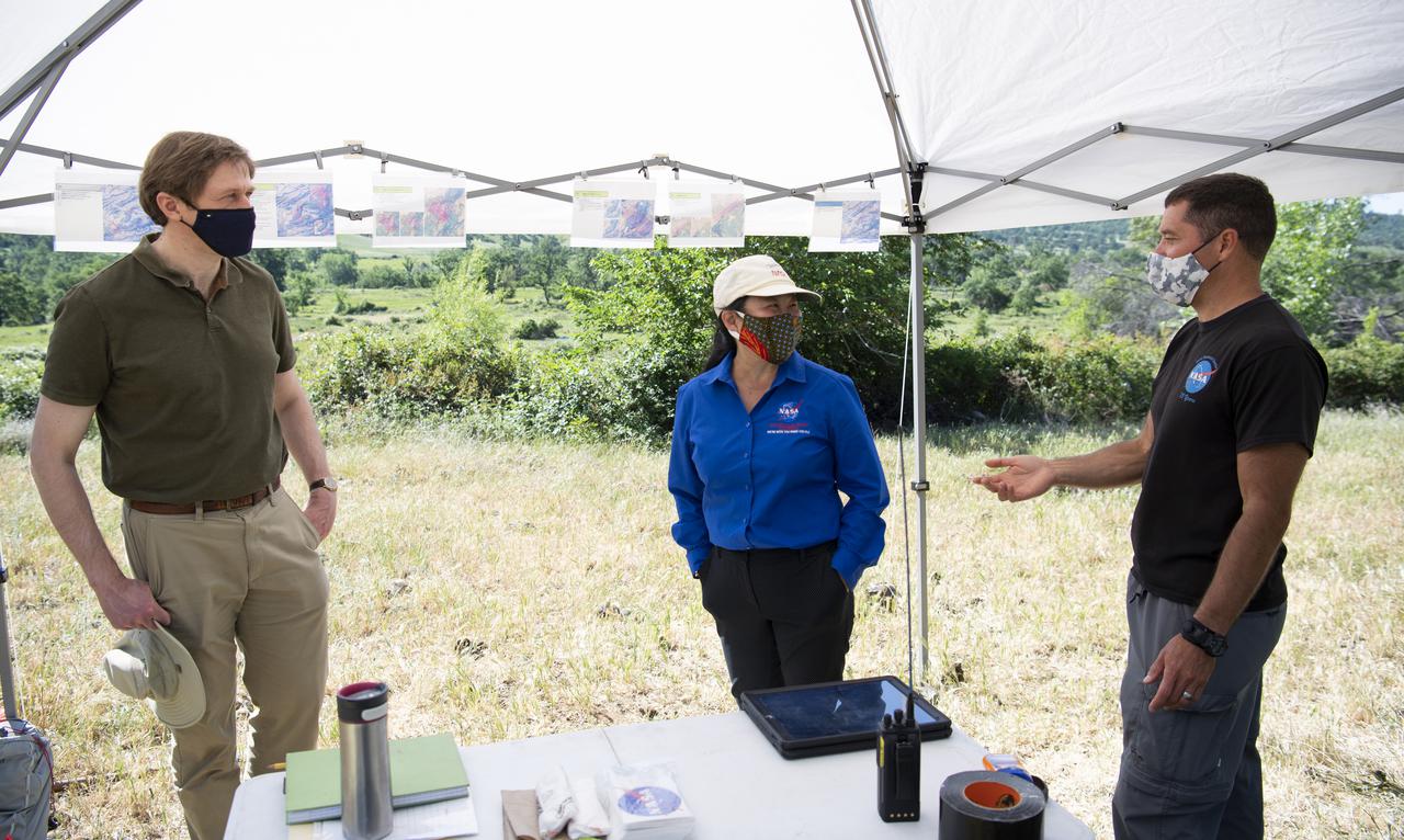 Joey Mercer, principle investigator for STEReO, the Scalable Traffic Management for Emergency Response Operations project, at NASA's Ames Research Center, right, speaks with Richard Barhydt, station director of the U.S. Forest Service's Pacific Southwest Research Station, left, and Huy Tran, director of aeronautics at NASA's Ames Research Center, center, during STEReO test activities, Tuesday, May 4, 2021 as Cal Fire conducts aerial fire fighting training exercises near Redding, California. STEReO, the Scalable Traffic Management for Emergency Response Operations project, led by NASA’s Ames Research Center, builds on NASA’s expertise in air traffic management, human factors research, and autonomous technology development to apply the agency’s work in Unmanned Aircraft Systems Traffic Management, or UTM, to public safety uses. Photo Credit: (NASA/Joel Kowsky)