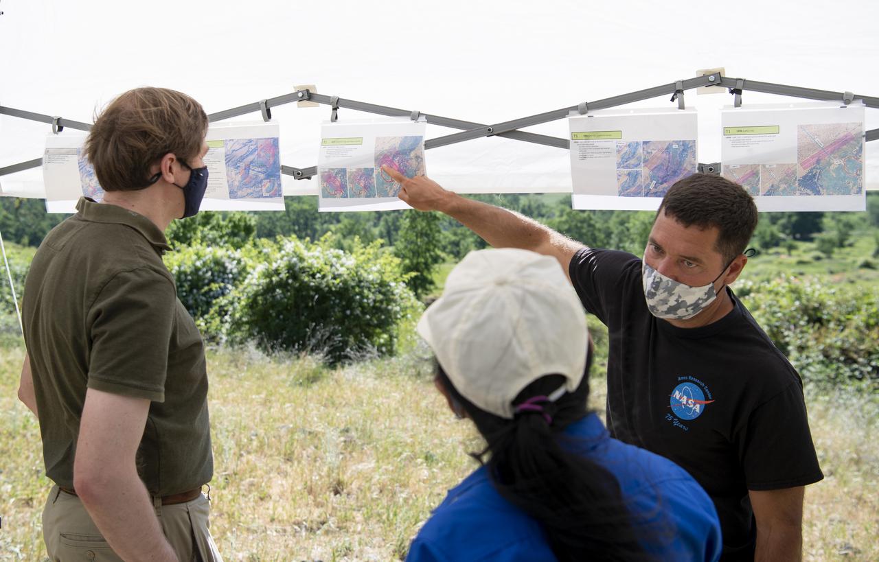Joey Mercer, principle investigator for STEReO, the Scalable Traffic Management for Emergency Response Operations project, at NASA's Ames Research Center, right, speaks with Richard Barhydt, station director of the U.S. Forest Service's Pacific Southwest Research Station, left, and Huy Tran, director of aeronautics at NASA's Ames Research Center, center, during STEReO test activities, Tuesday, May 4, 2021 as Cal Fire conducts aerial fire fighting training exercises near Redding, California. STEReO, the Scalable Traffic Management for Emergency Response Operations project, led by NASA’s Ames Research Center, builds on NASA’s expertise in air traffic management, human factors research, and autonomous technology development to apply the agency’s work in Unmanned Aircraft Systems Traffic Management, or UTM, to public safety uses. Photo Credit: (NASA/Joel Kowsky)