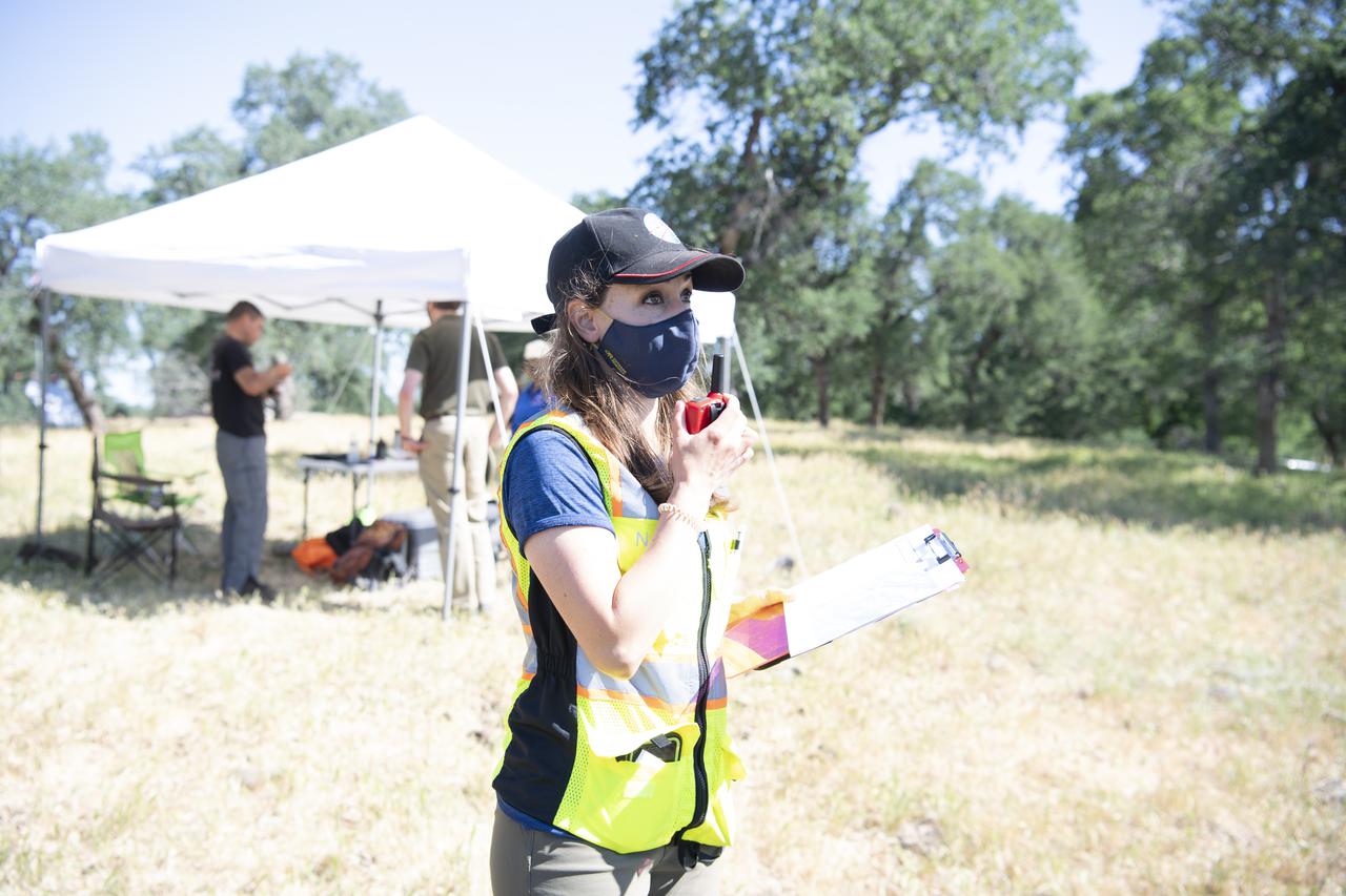 Lauren Claudatos, researcher for STEReO, the Scalable Traffic Management for Emergency Response Operations project, at NASA's Ames Research Center, is seen during simulated drone operations during STEReO field testing, Tuesday, May 4, 2021 as Cal Fire conducts aerial fire fighting training exercises near Redding, California.  STEReO, the Scalable Traffic Management for Emergency Response Operations project, led by NASA’s Ames Research Center, builds on NASA’s expertise in air traffic management, human factors research, and autonomous technology development to apply the agency’s work in Unmanned Aircraft Systems Traffic Management, or UTM, to public safety uses. Photo Credit: (NASA/Joel Kowsky)