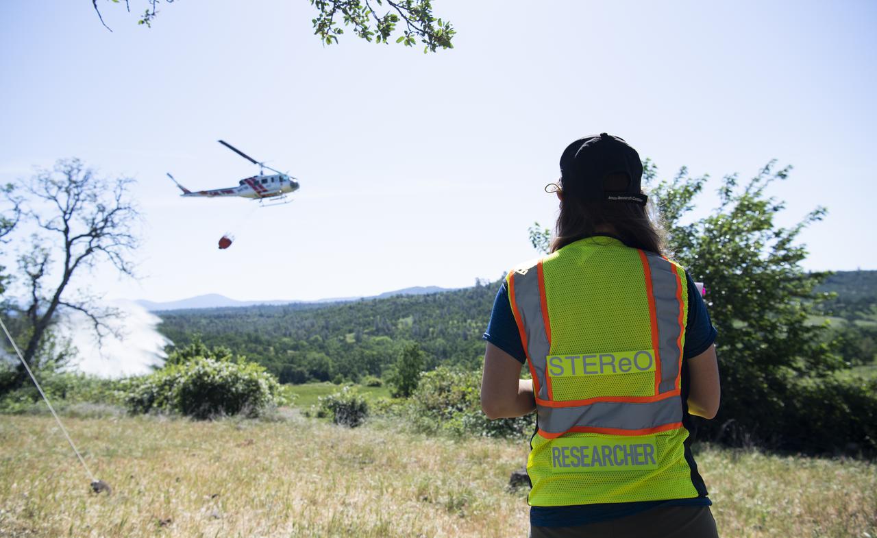 Lauren Claudatos, researcher for STEReO, the Scalable Traffic Management for Emergency Response Operations project, at NASA's Ames Research Center, is seen during simulated drone operations during STEReO field testing, Tuesday, May 4, 2021 as Cal Fire conducts aerial fire fighting training exercises near Redding, California.  STEReO, the Scalable Traffic Management for Emergency Response Operations project, led by NASA’s Ames Research Center, builds on NASA’s expertise in air traffic management, human factors research, and autonomous technology development to apply the agency’s work in Unmanned Aircraft Systems Traffic Management, or UTM, to public safety uses. Photo Credit: (NASA/Joel Kowsky)