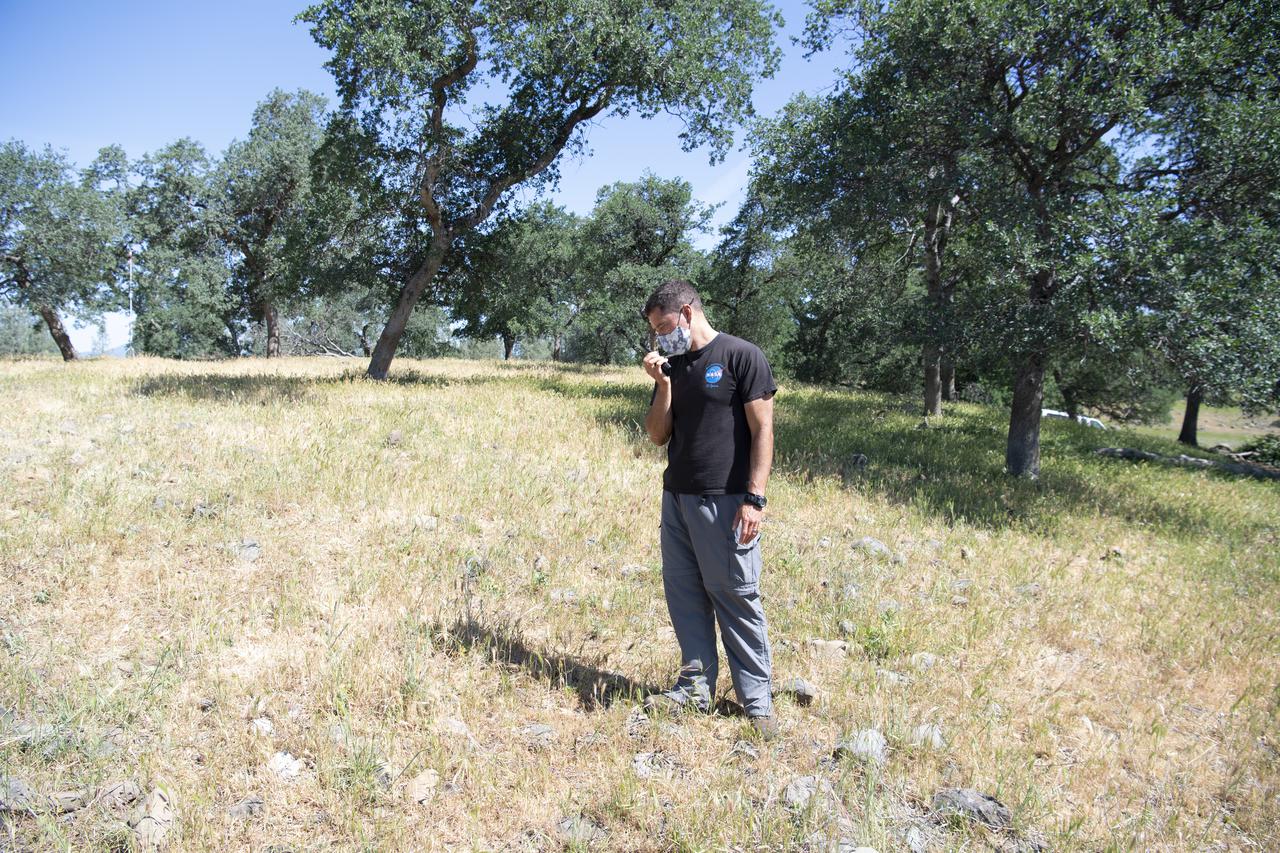Joey Mercer, principle investigator for STEReO, the Scalable Traffic Management for Emergency Response Operations project,  at NASA's Ames Research Center, is seen making a radio call during STEReO field testing, Tuesday, May 4, 2021 as Cal Fire conducts aerial fire fighting training exercises near Redding, California.  STEReO, the Scalable Traffic Management for Emergency Response Operations project, led by NASA’s Ames Research Center, builds on NASA’s expertise in air traffic management, human factors research, and autonomous technology development to apply the agency’s work in Unmanned Aircraft Systems Traffic Management, or UTM, to public safety uses. Photo Credit: (NASA/Joel Kowsky)