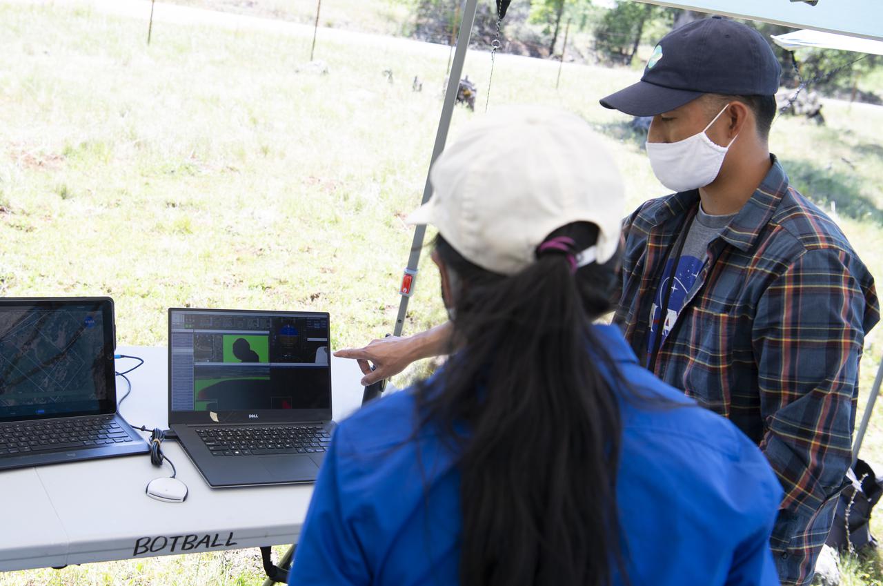 Josh Baculi, autonomy researcher for STEReO, the Scalable Traffic Management for Emergency Response Operations project, at NASA's Ames Research Center, right, speaks with Huy Tran, director of aeronautics at NASA's Ames Research Center, during STEReO field testing, Tuesday, May 4, 2021 as Cal Fire conducts aerial fire fighting training exercises near Redding, California.  STEReO, the Scalable Traffic Management for Emergency Response Operations project, led by NASA’s Ames Research Center, builds on NASA’s expertise in air traffic management, human factors research, and autonomous technology development to apply the agency’s work in Unmanned Aircraft Systems Traffic Management, or UTM, to public safety uses. Photo Credit: (NASA/Joel Kowsky)