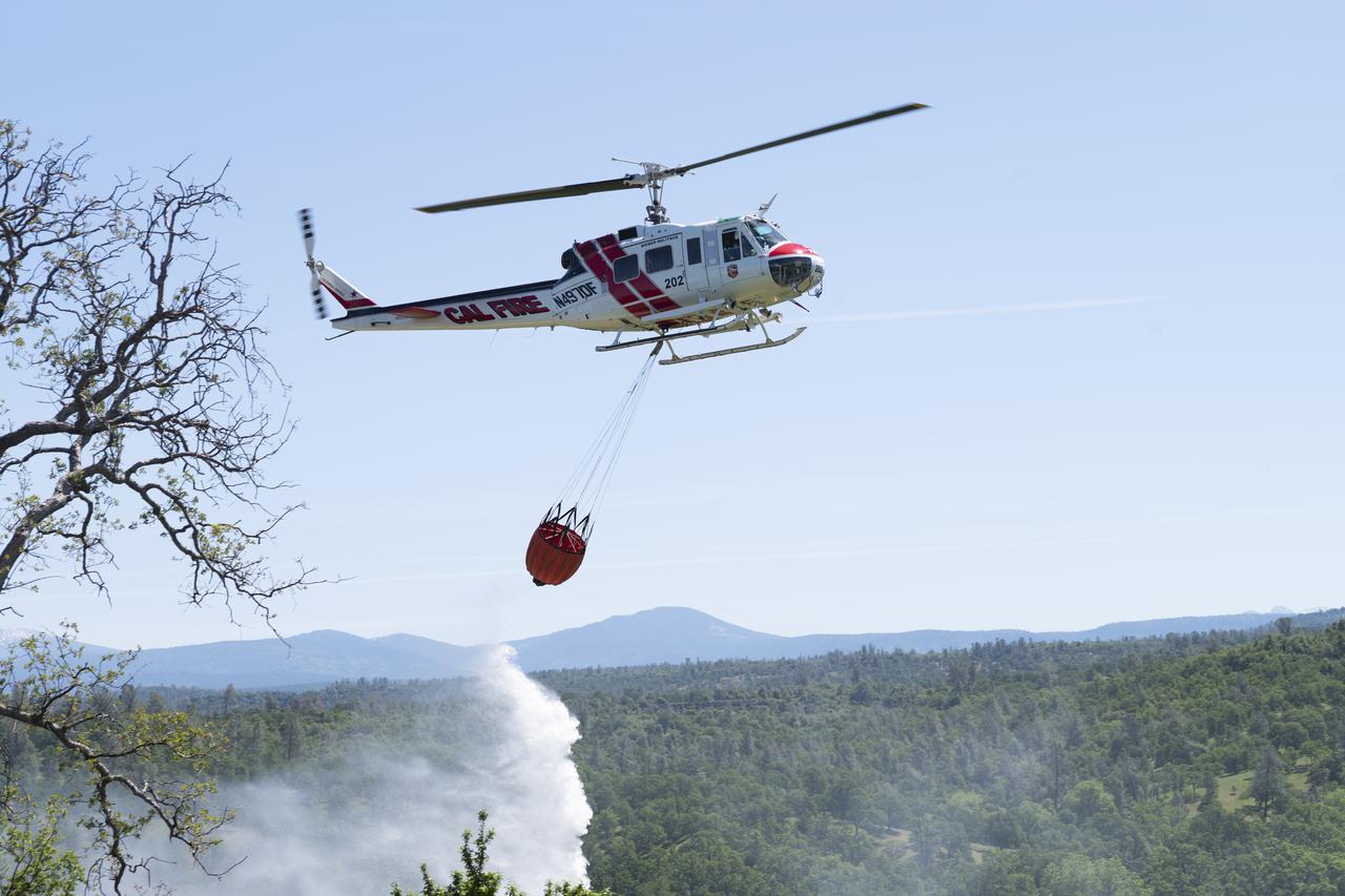 A Cal Fire UH-1H Super Huey helicopter conducts a water drop on a simulated wildfire, Tuesday, May 4, 2021 as Cal Fire conducts aerial fire fighting training exercises near Redding, California. STEReO, the Scalable Traffic Management for Emergency Response Operations project, led by NASA’s Ames Research Center, builds on NASA’s expertise in air traffic management, human factors research, and autonomous technology development to apply the agency’s work in Unmanned Aircraft Systems Traffic Management, or UTM, to public safety uses. Photo Credit: (NASA/Joel Kowsky)