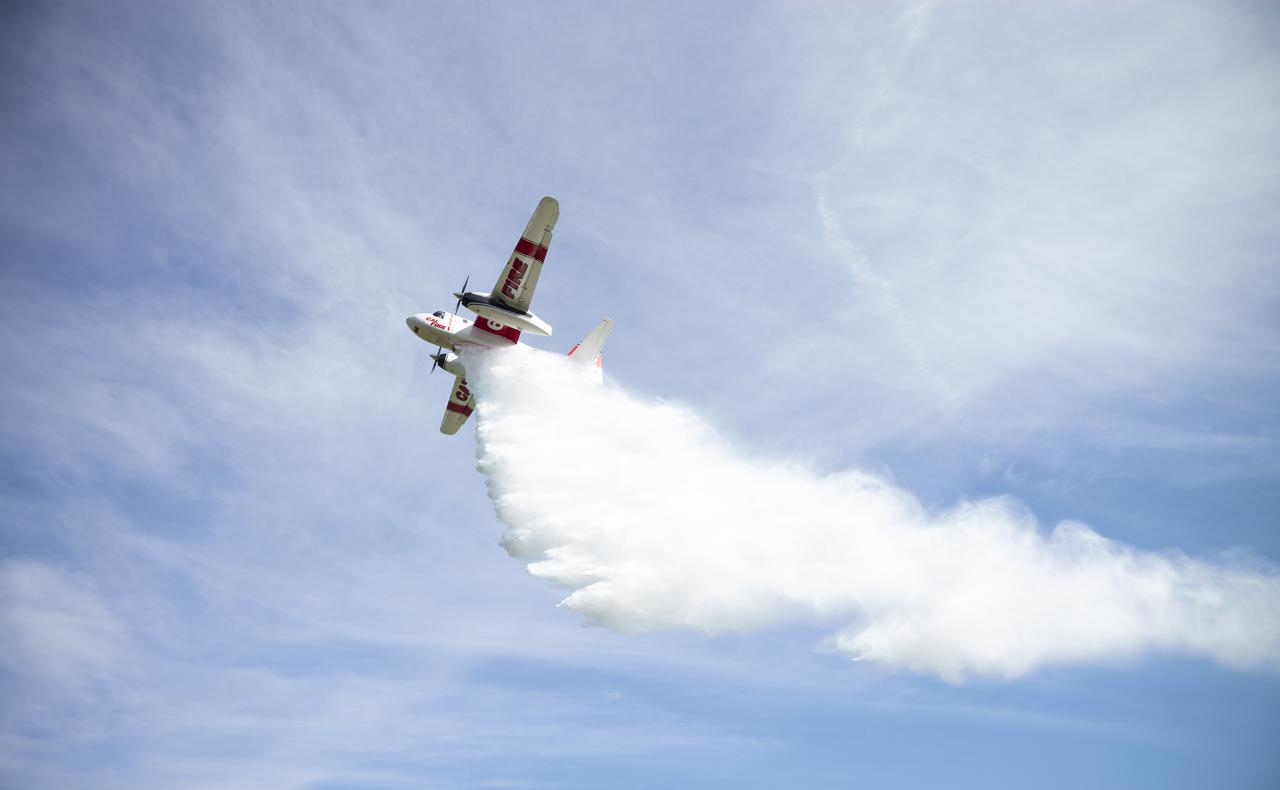 A Cal Fire S2-T airtanker is seen as it drops water on a simulated wildfire, Tuesday, May 4, 2021 as Cal Fire conducts aerial fire fighting training exercises near Redding, California.  STEReO, the Scalable Traffic Management for Emergency Response Operations project, led by NASA’s Ames Research Center, builds on NASA’s expertise in air traffic management, human factors research, and autonomous technology development to apply the agency’s work in Unmanned Aircraft Systems Traffic Management, or UTM, to public safety uses. Photo Credit: (NASA/Joel Kowsky)