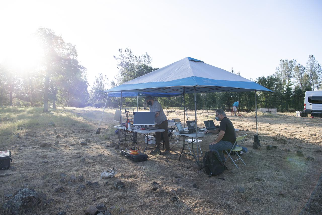 Zach Roberts, pilot computer operator for STEReO, the Scalable Traffic Management for Emergency Response Operations project, at NASA's Ames Research Center, left, and Bill McCarthy, software engineer and research laptop operator for STEReO, the Scalable Traffic Management for Emergency Response Operations project, at NASA's Ames Research Center, right, setup equipment for drone operations, Wednesday, May 5, 2021 as Cal Fire conducts aerial fire fighting training exercises near Redding, California.  STEReO, the Scalable Traffic Management for Emergency Response Operations project, led by NASA’s Ames Research Center, builds on NASA’s expertise in air traffic management, human factors research, and autonomous technology development to apply the agency’s work in Unmanned Aircraft Systems Traffic Management, or UTM, to public safety uses. Photo Credit: (NASA/Joel Kowsky)
