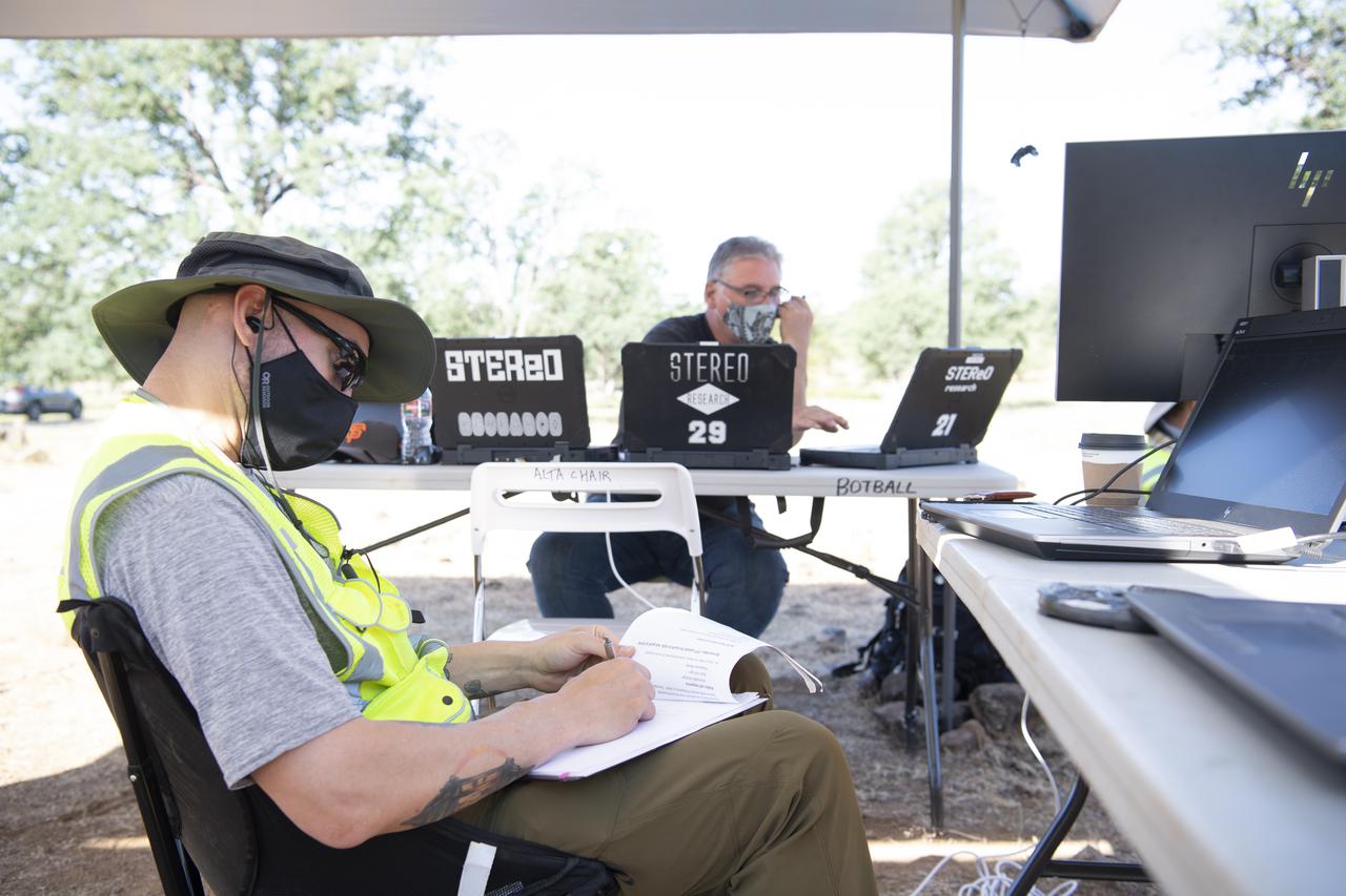 Zach Roberts, pilot computer operator for STEReO, the Scalable Traffic Management for Emergency Response Operations project, at NASA's Ames Research Center, left, Bill McCarthy, software engineer and research laptop operator for STEReO, at NASA's Ames Research Center, right, are seen during simulated drone operations as part of STEReO field testing, Wednesday, May 5, 2021 as Cal Fire conducts aerial fire fighting training exercises near Redding, California. STEReO, the Scalable Traffic Management for Emergency Response Operations project, led by NASA’s Ames Research Center, builds on NASA’s expertise in air traffic management, human factors research, and autonomous technology development to apply the agency’s work in Unmanned Aircraft Systems Traffic Management, or UTM, to public safety uses. Photo Credit: (NASA/Joel Kowsky)