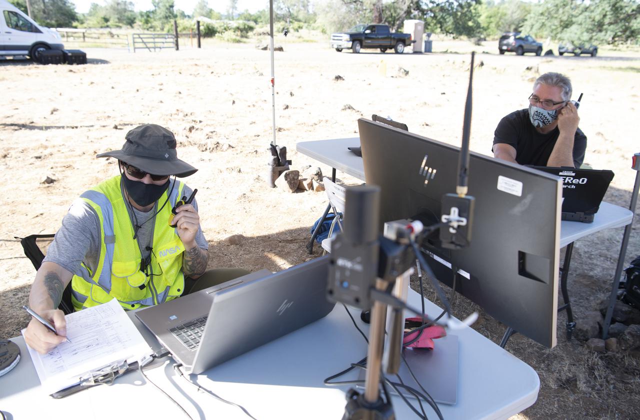 Zach Roberts, pilot computer operator for STEReO, the Scalable Traffic Management for Emergency Response Operations project, at NASA's Ames Research Center, right, Bill McCarthy, software engineer and research laptop operator for STEReO, at NASA's Ames Research Center, left, are seen during simulated drone operations as part of STEReO field testing, Wednesday, May 5, 2021 as Cal Fire conducts aerial fire fighting training exercises near Redding, California. STEReO, the Scalable Traffic Management for Emergency Response Operations project, led by NASA’s Ames Research Center, builds on NASA’s expertise in air traffic management, human factors research, and autonomous technology development to apply the agency’s work in Unmanned Aircraft Systems Traffic Management, or UTM, to public safety uses. Photo Credit: (NASA/Joel Kowsky)