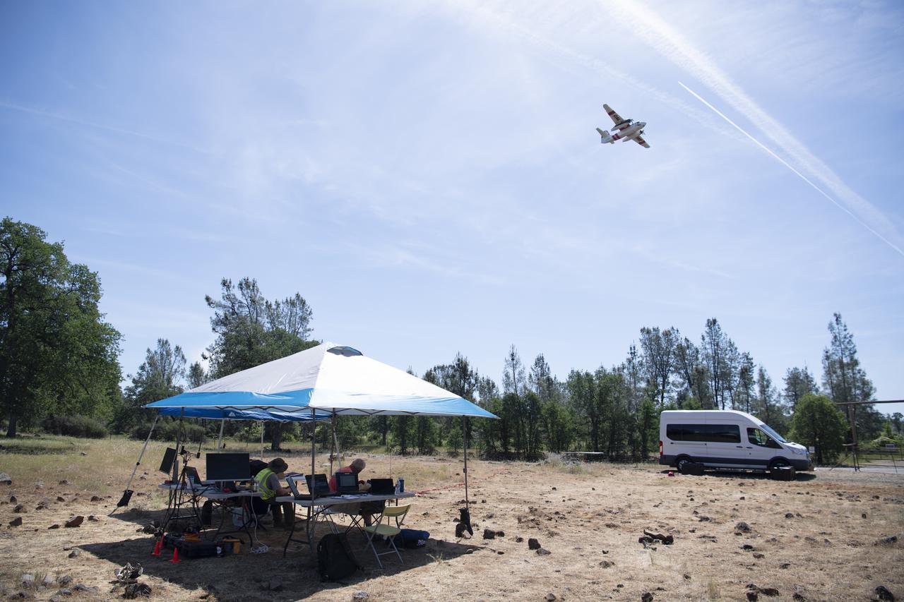 A Cal Fire S2-T airtanker is seen flying over STEReO, the Scalable Traffic Management for Emergency Response Operations project, team members during field testing, Wednesday, May 5, 2021 as Cal Fire conducts aerial fire fighting training exercises near Redding, California.  STEReO, the Scalable Traffic Management for Emergency Response Operations project, led by NASA’s Ames Research Center, builds on NASA’s expertise in air traffic management, human factors research, and autonomous technology development to apply the agency’s work in Unmanned Aircraft Systems Traffic Management, or UTM, to public safety uses. Photo Credit: (NASA/Joel Kowsky)