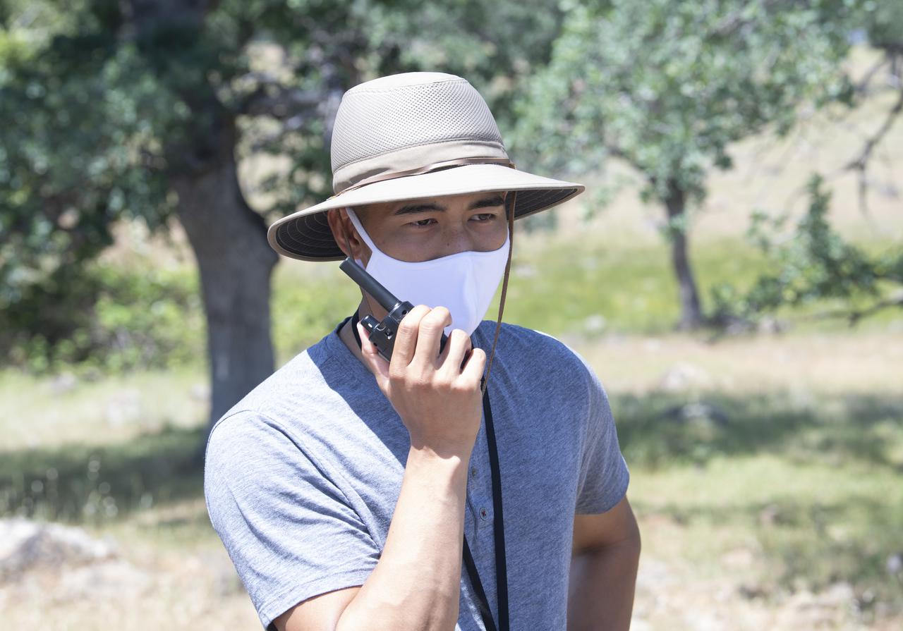 Josh Baculi, autonomy researcher for STEReO, the Scalable Traffic Management for Emergency Response Operations project, at NASA's Ames Research Center, makes a radio call during simulated drone operations as part of STEReO field testing, Wednesday, May 5, 2021 as Cal Fire conducts aerial fire fighting training exercises near Redding, California.  STEReO, the Scalable Traffic Management for Emergency Response Operations project, led by NASA’s Ames Research Center, builds on NASA’s expertise in air traffic management, human factors research, and autonomous technology development to apply the agency’s work in Unmanned Aircraft Systems Traffic Management, or UTM, to public safety uses. Photo Credit: (NASA/Joel Kowsky)