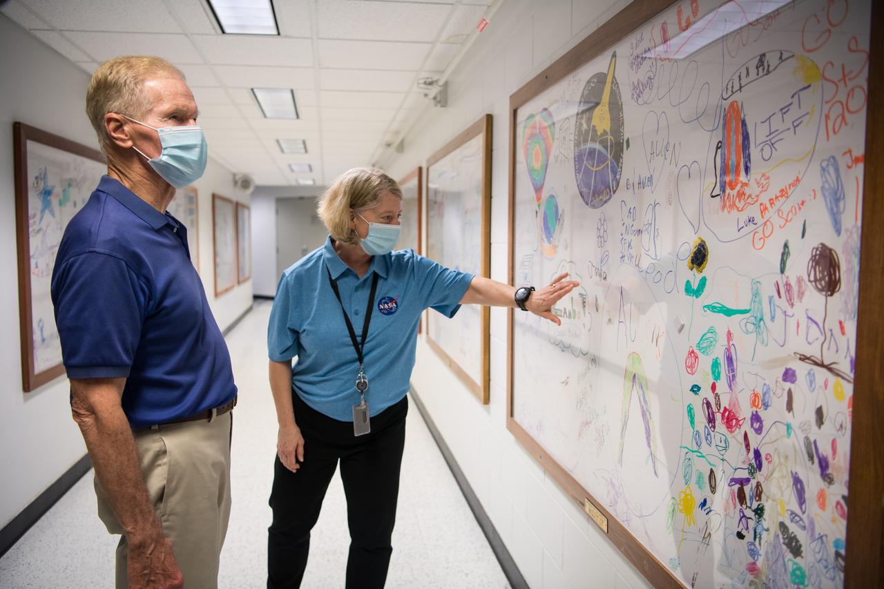 NASA Deputy Administrator Pam Melroy, right, shows NASA Administrator Bill Nelson the white board created by the families of the astronauts of the STS-120 mission, after a tour of the firing rooms in the Launch Control Center (LCC), Wednesday, July 28, 2021, at NASA’s Kennedy Space Center in Florida. Deputy Administrator Melroy served as commander on STS-120 which was her third and last spaceflight. Photo Credit: (NASA/Aubrey Gemignani)