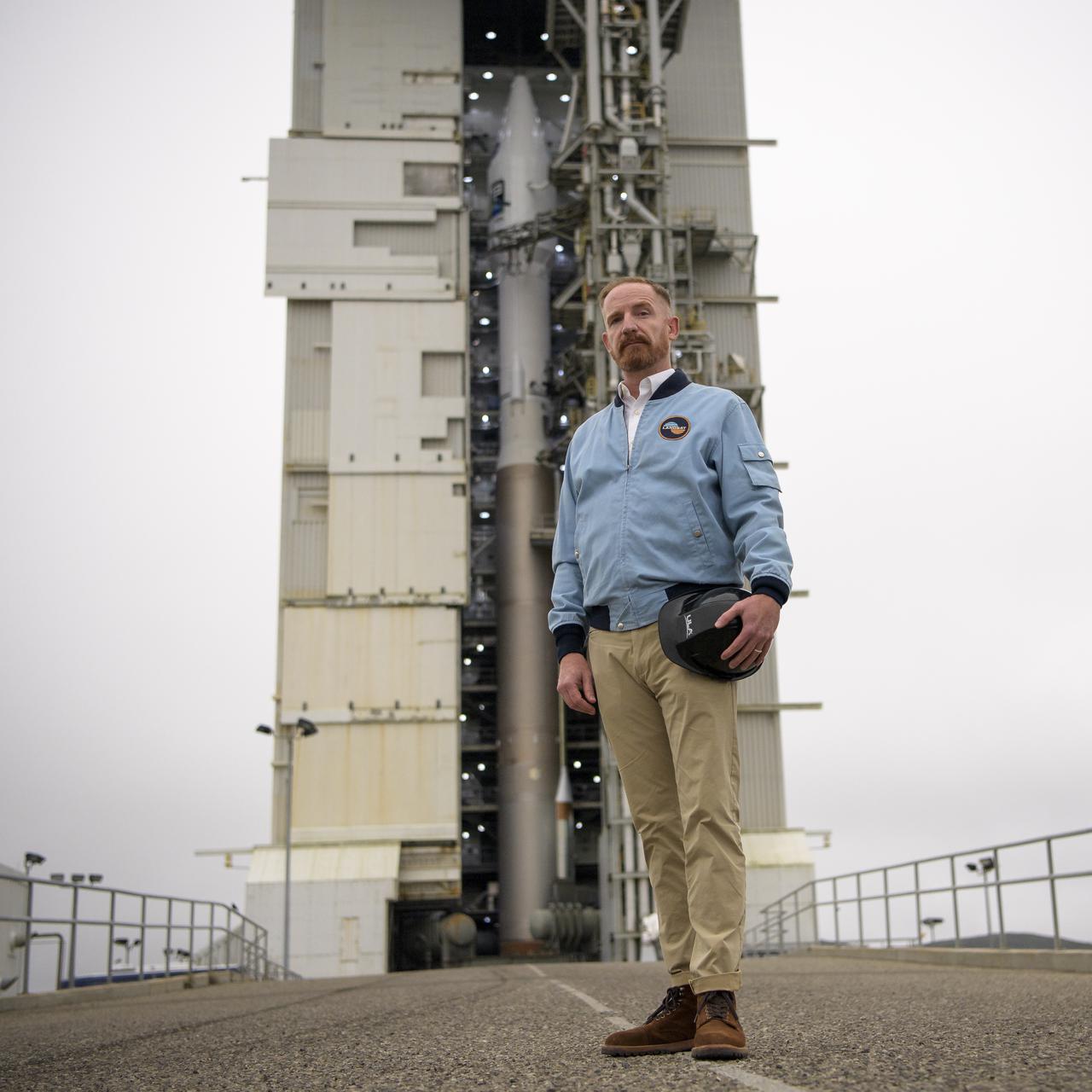 Actor Marc Evan Jackson poses for a photograph by the United Launch Alliance (ULA) Atlas V rocket with the Landsat 9 satellite onboard, Sunday, Sept. 26, 2021, at Vandenberg Space Force Base in California. The Landsat 9 satellite, a joint NASA/U.S. Geological Survey mission that will continue the legacy of monitoring Earth’s land and coastal regions, is scheduled for liftoff Monday, Sept. 27. Photo Credit: (NASA/Bill Ingalls)