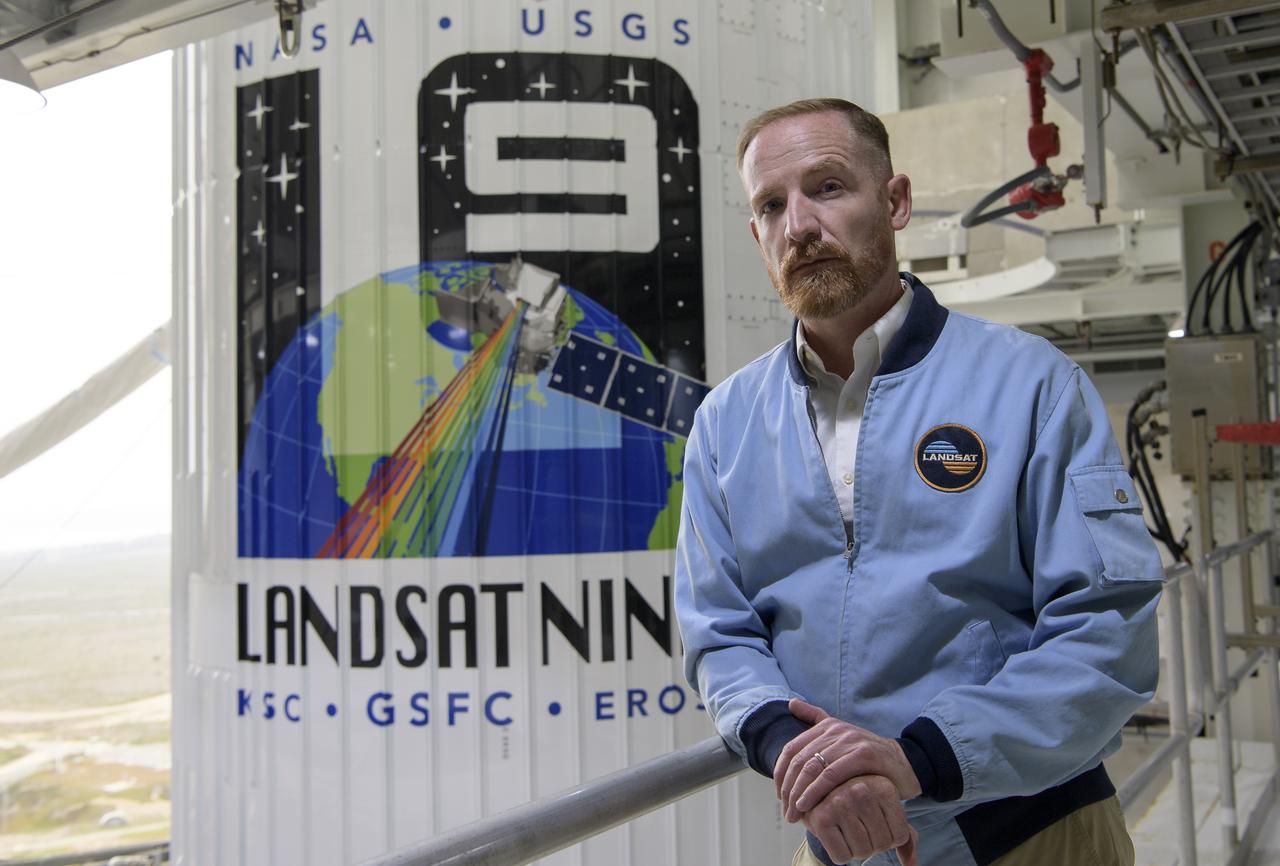 Actor Marc Evan Jackson poses for a photograph by the United Launch Alliance (ULA) Atlas V rocket with the Landsat 9 satellite onboard, Sunday, Sept. 26, 2021, at Vandenberg Space Force Base in California. The Landsat 9 satellite, a joint NASA/U.S. Geological Survey mission that will continue the legacy of monitoring Earth’s land and coastal regions, is scheduled for liftoff Monday, Sept. 27. Photo Credit: (NASA/Bill Ingalls)