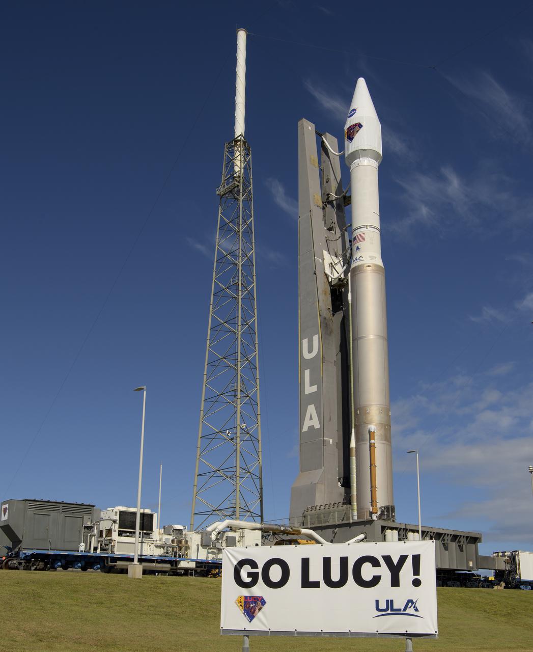 A United Launch Alliance Atlas V rocket with the Lucy spacecraft aboard is seen as it is rolled out of the Vertical Integration Facility to the launch pad at Space Launch Complex 41, Thursday, Oct. 14, 2021, at Cape Canaveral Space Force Station in Florida. Lucy will be the first spacecraft to study Jupiter's Trojan Asteroids. Like the mission's namesake – the fossilized human ancestor, "Lucy," whose skeleton provided unique insight into humanity's evolution – Lucy will revolutionize our knowledge of planetary origins and the formation of the solar system. Photo Credit: (NASA/Bill Ingalls)