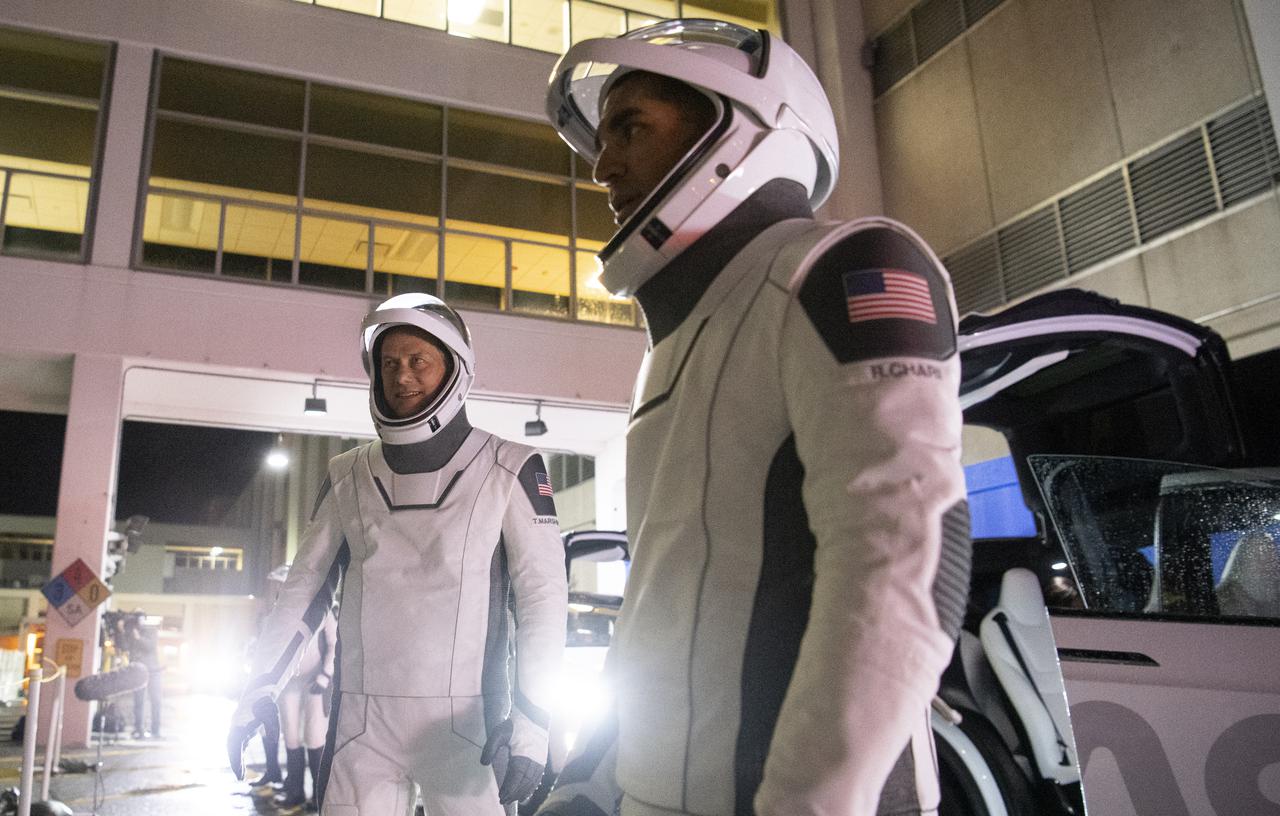 NASA astronauts Raja Chari, right, and Tom Marshburn, left, wearing SpaceX spacesuits, are seen as they prepare to depart the Neil  A. Armstrong Operations and Checkout Building for Launch Complex 39A during a dress rehearsal prior to the Crew-3 mission launch, Thursday, Oct. 28, 2021, at NASA’s Kennedy Space Center in Florida. NASA’s SpaceX Crew-3 mission is the third crew rotation mission of the SpaceX Crew Dragon spacecraft and Falcon 9 rocket to the International Space Station as part of the agency’s Commercial Crew Program. Chari, Marshburn, NASA astronaut Kayla Barron and ESA (European Space Agency) astronaut Matthias Maurer are scheduled to launch at Oct. 31 at 2:21 a.m. ET, from Launch Complex 39A at the Kennedy Space Center. Photo Credit: (NASA/Joel Kowsky)