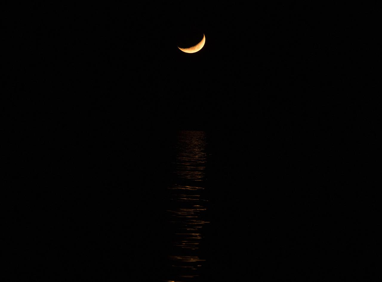 The Moon is seen just before the SpaceX Crew Dragon Endeavour spacecraft lands with NASA astronauts Shane Kimbrough and Megan McArthur, Japan Aerospace Exploration Agency (JAXA) astronaut Aki Hoshide, and ESA (European Space Agency) astronaut Thomas Pesquet aboard in the Gulf of Mexico off the coast of Pensacola, Florida, Monday, Nov. 8, 2021. NASA’s SpaceX Crew-2 mission is the second operational mission of the SpaceX Crew Dragon spacecraft and Falcon 9 rocket to the International Space Station as part of the agency’s Commercial Crew Program. Photo Credit: (NASA/Aubrey Gemignani)