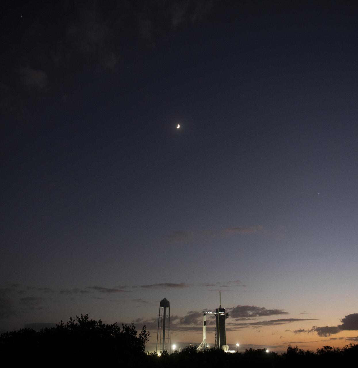 Jupiter, upper left, the Moon, center, and Venus, lower right, are seen above a SpaceX Falcon 9 rocket with the company's Crew Dragon spacecraft onboard at Launch Complex 39A as preparations continue for the Crew-3 mission, Tuesday, Nov. 9, 2021, at NASA’s Kennedy Space Center in Florida. NASA’s SpaceX Crew-3 mission is the third crew rotation mission of the SpaceX Crew Dragon spacecraft and Falcon 9 rocket to the International Space Station as part of the agency’s Commercial Crew Program. NASA astronauts Raja Chari, Tom Marshburn, Kayla Barron, and ESA (European Space Agency) astronaut Matthias Maurer are scheduled to launch no earlier than Nov. 10 at 9:03 p.m. EST, from Launch Complex 39A at the Kennedy Space Center. Photo Credit: (NASA/Joel Kowsky)