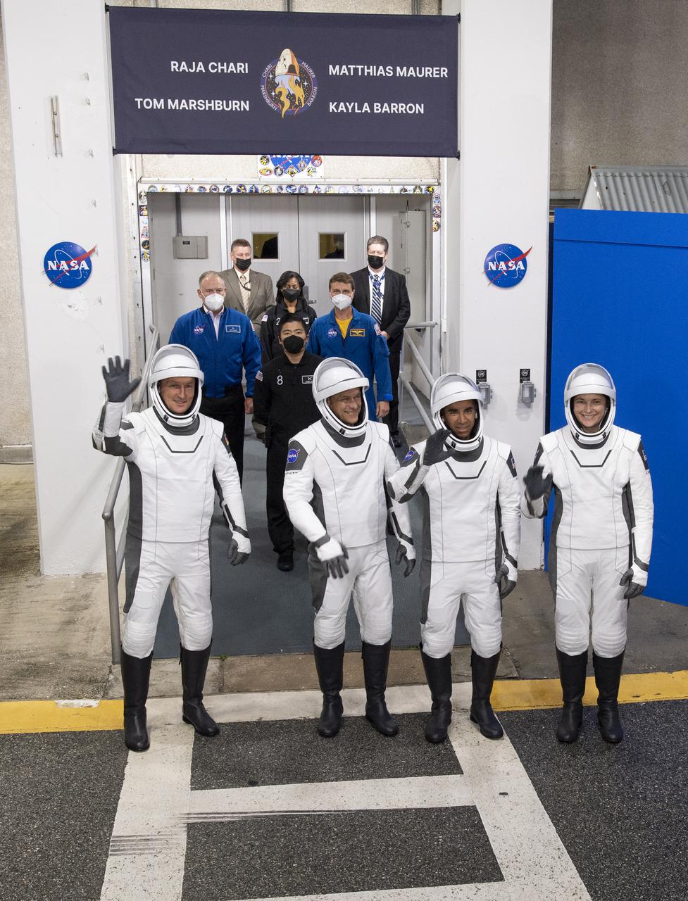 ESA (European Space Agency) astronaut Matthias Maurer, left, and NASA astronauts Tom Marshburn, second from left, Raja Chari, second from right, and Kayla Barron, right, wearing SpaceX spacesuits, are seen as they prepare to depart the Neil A. Armstrong Operations and Checkout Building for Launch Complex 39A to board the SpaceX Crew Dragon spacecraft for the Crew-3 mission launch, Wednesday, Nov. 10, 2021, at NASA’s Kennedy Space Center in Florida. NASA’s SpaceX Crew-3 mission is the third crew rotation mission of the SpaceX Crew Dragon spacecraft and Falcon 9 rocket to the International Space Station as part of the agency’s Commercial Crew Program. Chari, Marshburn, Barron, Maurer are scheduled to launch at 9:03 p.m. EST, from Launch Complex 39A at the Kennedy Space Center. Photo Credit: (NASA/Joel Kowsky)