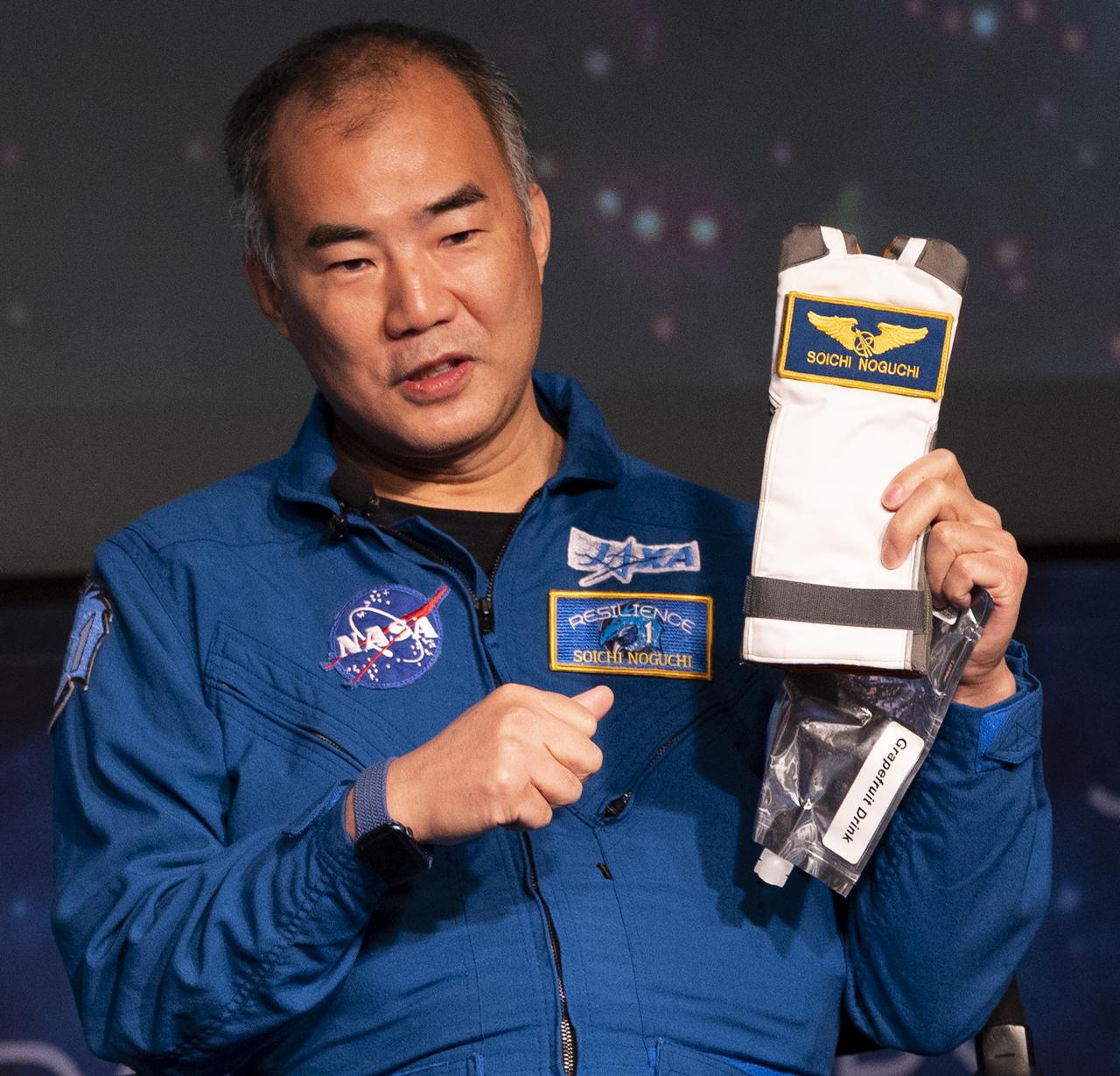 Japan Aerospace Exploration Agency (JAXA) astronaut Soichi Noguchi holds up a drink bag holder from his mission aboard the International Space Station as he speaks with employees of the Space Operations and Exploration Systems Development Mission Directorates about the Crew-1 mission with fellow crew members NASA astronauts Mike Hopkins, Victor Glover, and Shannon Walker, Monday, Nov. 15, 2021, at the Mary W. Jackson NASA Headquarters Building in Washington. Hopkins, Glover, Walker, and Noguchi launched on the first crew rotation mission to the International Space Station for SpaceX’s Falcon 9 and Crew Dragon spacecraft as part of the agency’s Commercial Crew Program and spent 168 days in space across Expeditions 64 and 65. Photo Credit: (NASA/Joel Kowsky)