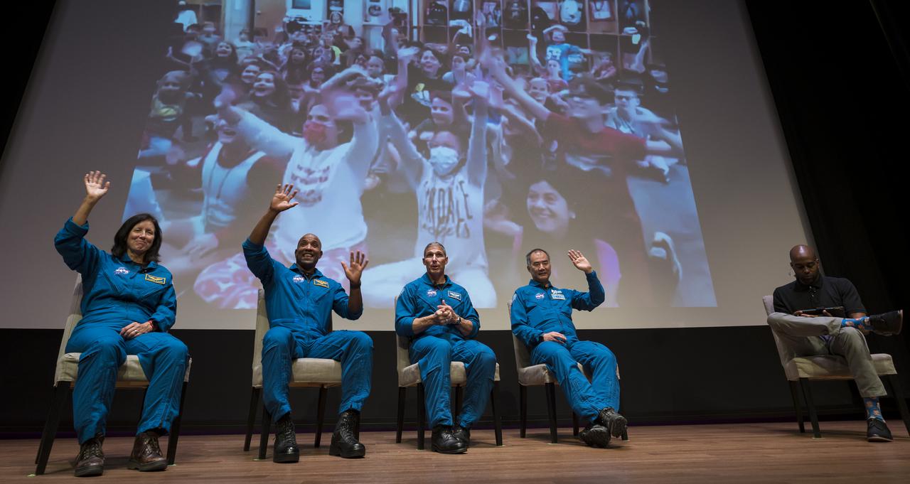 SpaceX Crew-1 NASA astronauts, from left to right, Shannon Walker, Victor Glover, Mike Hopkins, and Japan Aerospace Exploration Agency (JAXA) astronaut Soichi Noguchi, wave at students during a live question and answer session with National Museum of African American History and Culture (NMAAHC) STEM educator  Christopher Williams in the Oprah Winfrey Theater at the NMAAHC, Tuesday, Nov. 16, 2021, in Washington. Hopkins, Glover, Walker, and Noguchi launched on the first crew rotation mission to the International Space Station for SpaceX’s Falcon 9 and Crew Dragon spacecraft as part of the agency’s Commercial Crew Program and spent 168 days in space across Expeditions 64 and 65. Photo Credit: (NASA/Aubrey Gemignani)