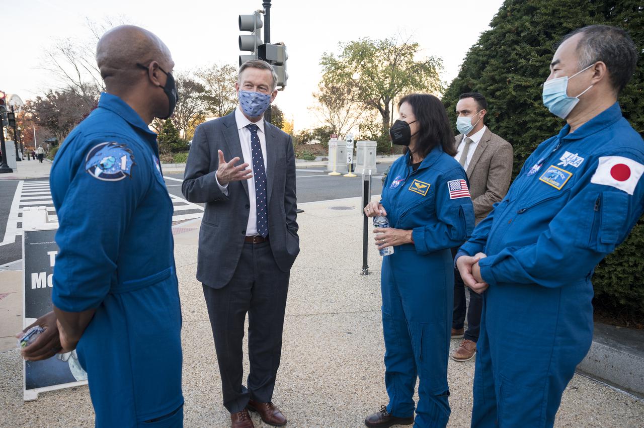 SpaceX Crew-1 NASA astronauts Victor Glover,  left, and Shannon Walker, second from right, and Japan Aerospace Exploration Agency (JAXA) astronaut Soichi Noguchi, right, speak with Senator John Hickenlooper, D-Colo, at the Destination Station mobile exhibition on Capitol Hill, Wednesday, Nov. 17, 2021, in Washington. Walker, Glover, Noguchi, and NASA astronaut Mike Hopkins, launched on the first crew rotation mission to the International Space Station for SpaceX’s Falcon 9 and Crew Dragon spacecraft as part of the agency’s Commercial Crew Program and spent 168 days in space across Expeditions 64 and 65. Photo Credit: (NASA/Aubrey Gemignani)