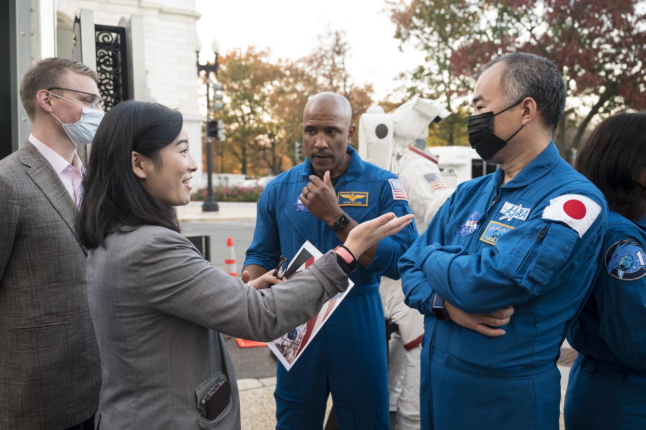SpaceX Crew-1 NASA astronaut Victor Glover, center, and Japan Aerospace Exploration Agency (JAXA) astronaut Soichi Noguchi, right, speak with visitors at the Destination Station mobile exhibition on Capitol Hill, Wednesday, Nov. 17, 2021, in Washington.Glover, Noguchi, and NASA astronauts Mike Hopkins and Shannon Walker, launched on the first crew rotation mission to the International Space Station for SpaceX’s Falcon 9 and Crew Dragon spacecraft as part of the agency’s Commercial Crew Program and spent 168 days in space across Expeditions 64 and 65. Photo Credit: (NASA/Aubrey Gemignani)