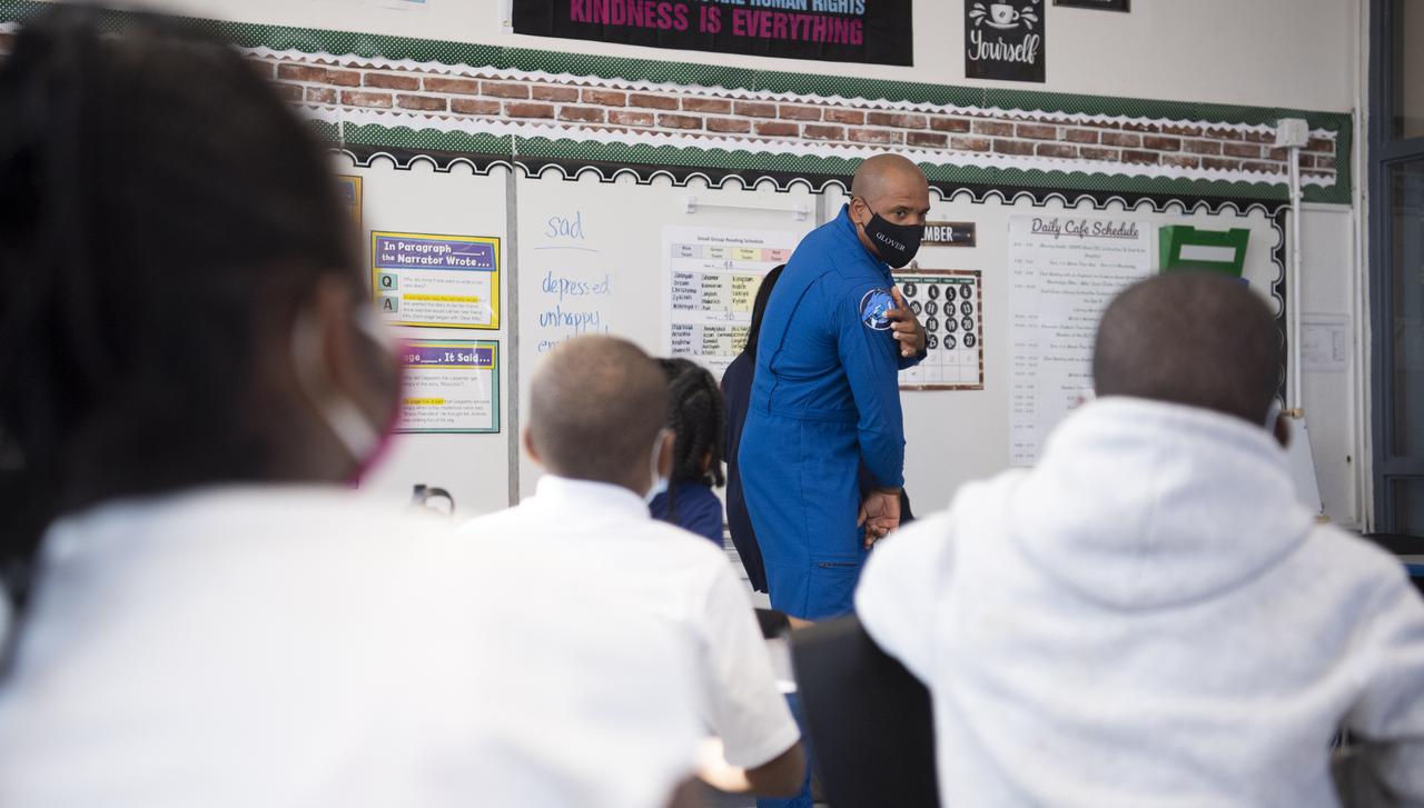 NASA astronaut Victor Glover points to the Crew Dragon spacecraft on the Crew-1 mission patch as he speaks with students about his time aboard the International Space Station during the Crew-1 mission, Thursday, Nov. 18, 2021, at Garfield Elementary School in Washington, DC. Glover and fellow NASA astronauts Shannon Walker, Mike Hopkins, and Japan Aerospace Exploration Agency (JAXA) astronaut Soichi Noguchi launched on the first crew rotation mission to the International Space Station for SpaceX’s Falcon 9 and Crew Dragon spacecraft as part of the agency’s Commercial Crew Program and spent 168 days in space across Expeditions 64 and 65. Photo Credit: (NASA/Joel Kowsky)