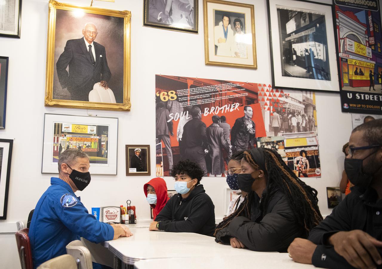 NASA astronaut Mike Hopkins speaks with students about his time aboard the International Space Station, Thursday, Nov. 18, 2021, at Ben’s Chili Bowl in Washington, DC. Students from Cardozo Educational Campus, Friendship Technology Preparatory High School, McKinley Technical High School, Phelps High School, and Wilson High School heard NASA astronauts Hopkins, Victor Glover, and Shannon Walker speak about the Crew-1 mission, the first crew rotation mission to the International Space Station for SpaceX’s Falcon 9 and Crew Dragon spacecraft as part of the agency’s Commercial Crew Program and the 168 days they spent in space across Expeditions 64 and 65. Photo Credit: (NASA/Joel Kowsky)