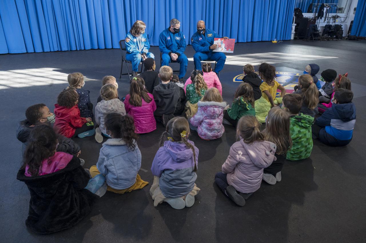 SpaceX Crew-1 NASA astronauts, from left, Shannon Walker, Mike Hopkins, and Victor Glover read a book to students from the Learn DC public charter school at Joint Base Anacostia-Bolling (JBAB), Friday, Nov. 19, 2021, in Washington. Hopkins, Glover, Walker, and Japan Aerospace Exploration Agency (JAXA) astronaut Soichi Noguchi, launched on the first crew rotation mission to the International Space Station for SpaceX’s Falcon 9 and Crew Dragon spacecraft as part of the agency’s Commercial Crew Program and spent 168 days in space across Expeditions 64 and 65. Photo Credit: (NASA/Aubrey Gemignani)