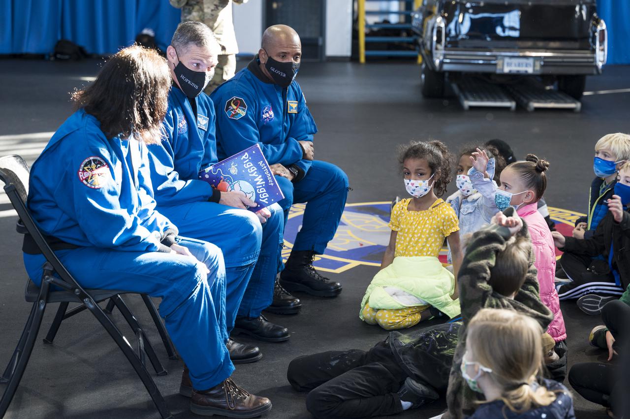 SpaceX Crew-1 NASA astronauts, from left, Shannon Walker, Mike Hopkins, and Victor Glover answer questions by students from the Learn DC public charter school at Joint Base Anacostia-Bolling (JBAB), Friday, Nov. 19, 2021, in Washington. Hopkins, Glover, Walker, and Japan Aerospace Exploration Agency (JAXA) astronaut Soichi Noguchi, launched on the first crew rotation mission to the International Space Station for SpaceX’s Falcon 9 and Crew Dragon spacecraft as part of the agency’s Commercial Crew Program and spent 168 days in space across Expeditions 64 and 65. Photo Credit: (NASA/Aubrey Gemignani)