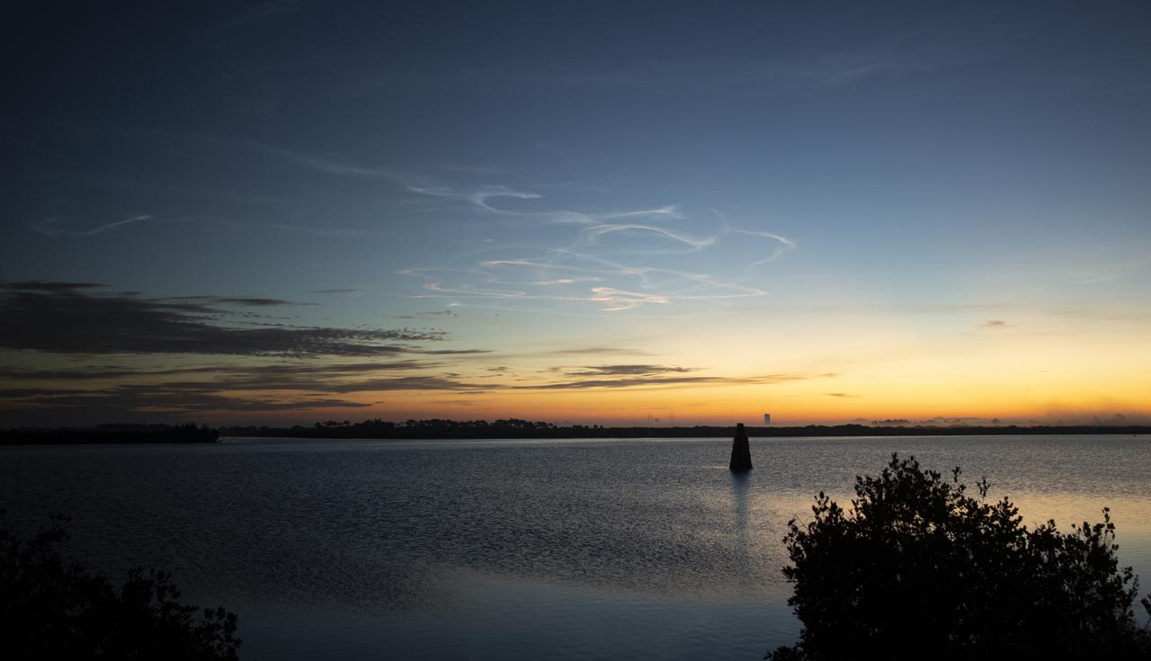 Contrails are seen illuminated in the sky as the Sun begins to rise following the launch of a United Launch Alliance Atlas V rocket on the Department of Defense’s Space Test Program 3 (STP-3) mission from Space Launch Complex 41 at Cape Canaveral Space Force Station, Tuesday, Dec. 7, 2021, from NASA’s Kennedy Space Center in Florida. The mission’s Space Test Program Satellite-6 (STPSat-6) spacecraft hosts NASA’s Laser Communications Relay Demonstration (LCRD) and the NASA-U.S. Naval Research Laboratory Ultraviolet Spectro-Coronagraph (UVSC) Pathfinder.  Photo Credit: (NASA/Joel Kowsky)