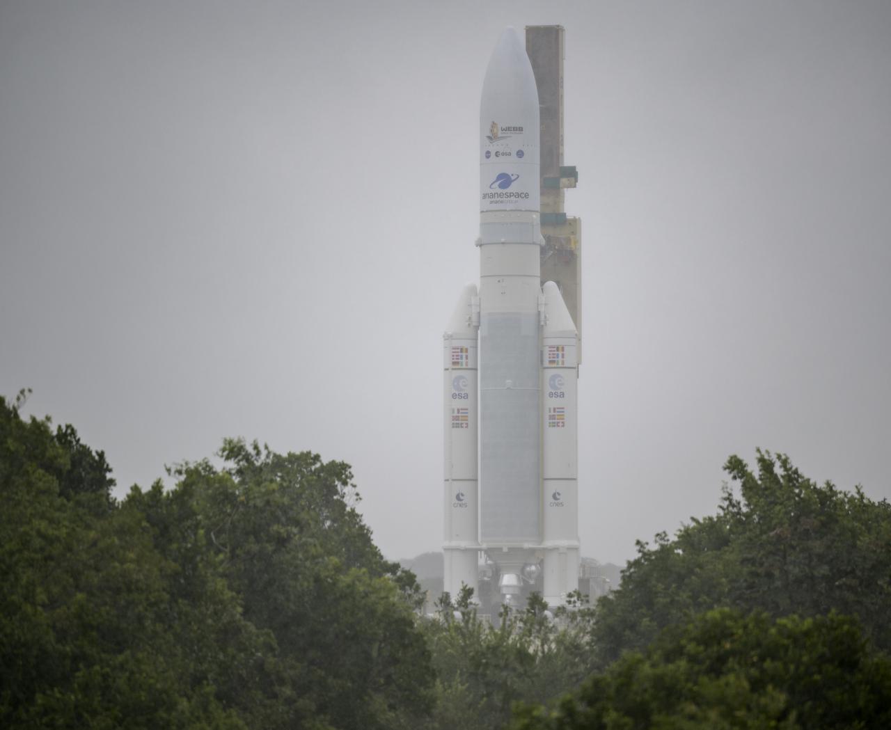 Arianespace's Ariane 5 rocket with NASA’s James Webb Space Telescope onboard, is rolled out in the rain to the launch pad, Thursday, Dec. 23, 2021, at Europe’s Spaceport, the Guiana Space Center in Kourou, French Guiana. The James Webb Space Telescope (sometimes called JWST or Webb) is a large infrared telescope with a 21.3 foot (6.5 meter) primary mirror. The observatory will study every phase of cosmic history—from within our solar system to the most distant observable galaxies in the early universe. Photo Credit: (NASA/Bill Ingalls)