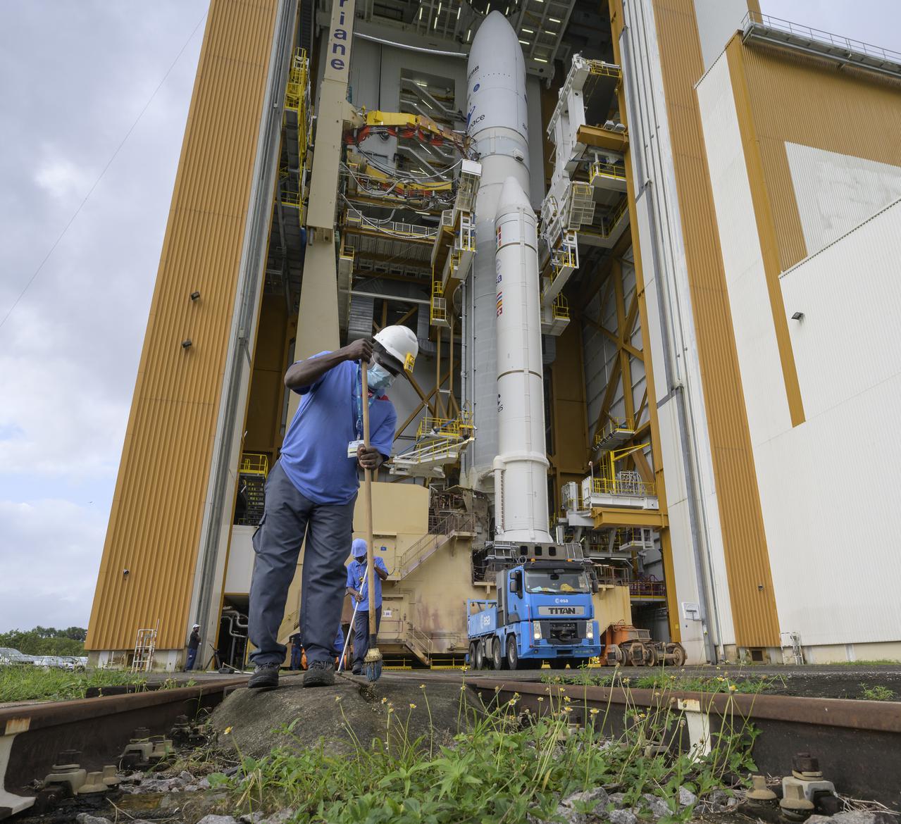Workers sweep the tracks in advance of the rollout to the launch pad of Arianespace's Ariane 5 rocket with NASA’s James Webb Space Telescope onboard, Thursday, Dec. 23, 2021, at Europe’s Spaceport, the Guiana Space Center in Kourou, French Guiana. The James Webb Space Telescope (sometimes called JWST or Webb) is a large infrared telescope with a 21.3 foot (6.5 meter) primary mirror. The observatory will study every phase of cosmic history—from within our solar system to the most distant observable galaxies in the early universe. Photo Credit: (NASA/Bill Ingalls)